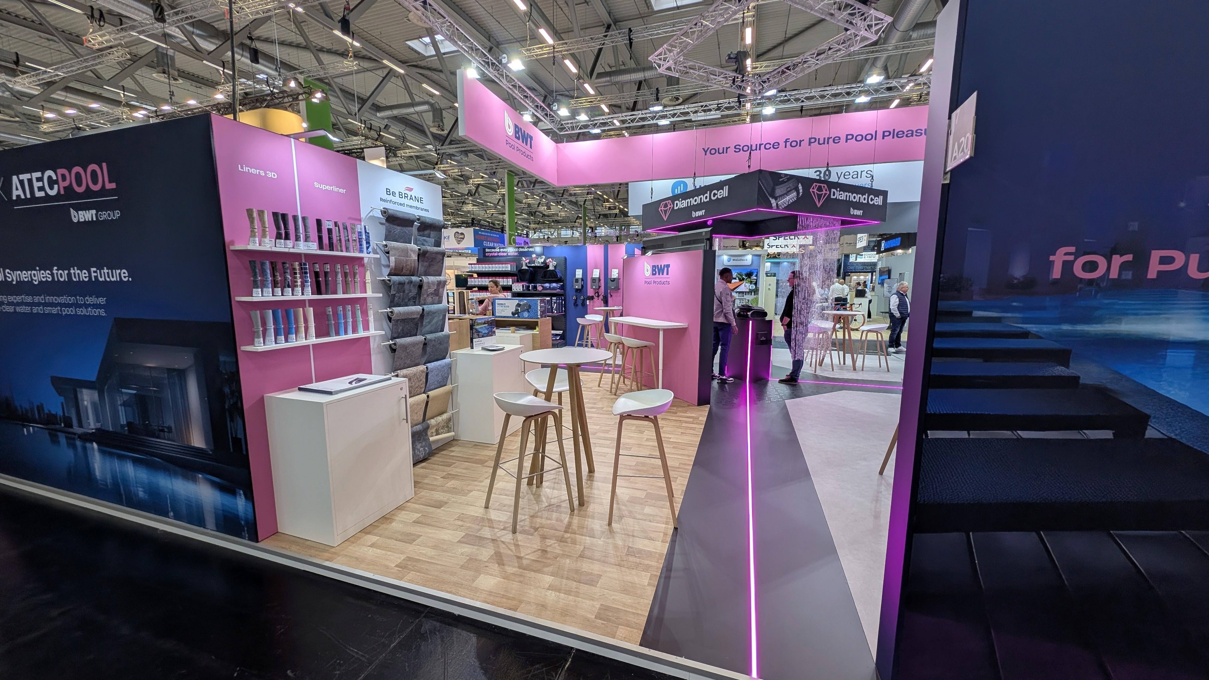 Vue centrale du stand BWT à Aquanale 2025 avec scénographie lumineuse et zones de démonstration"