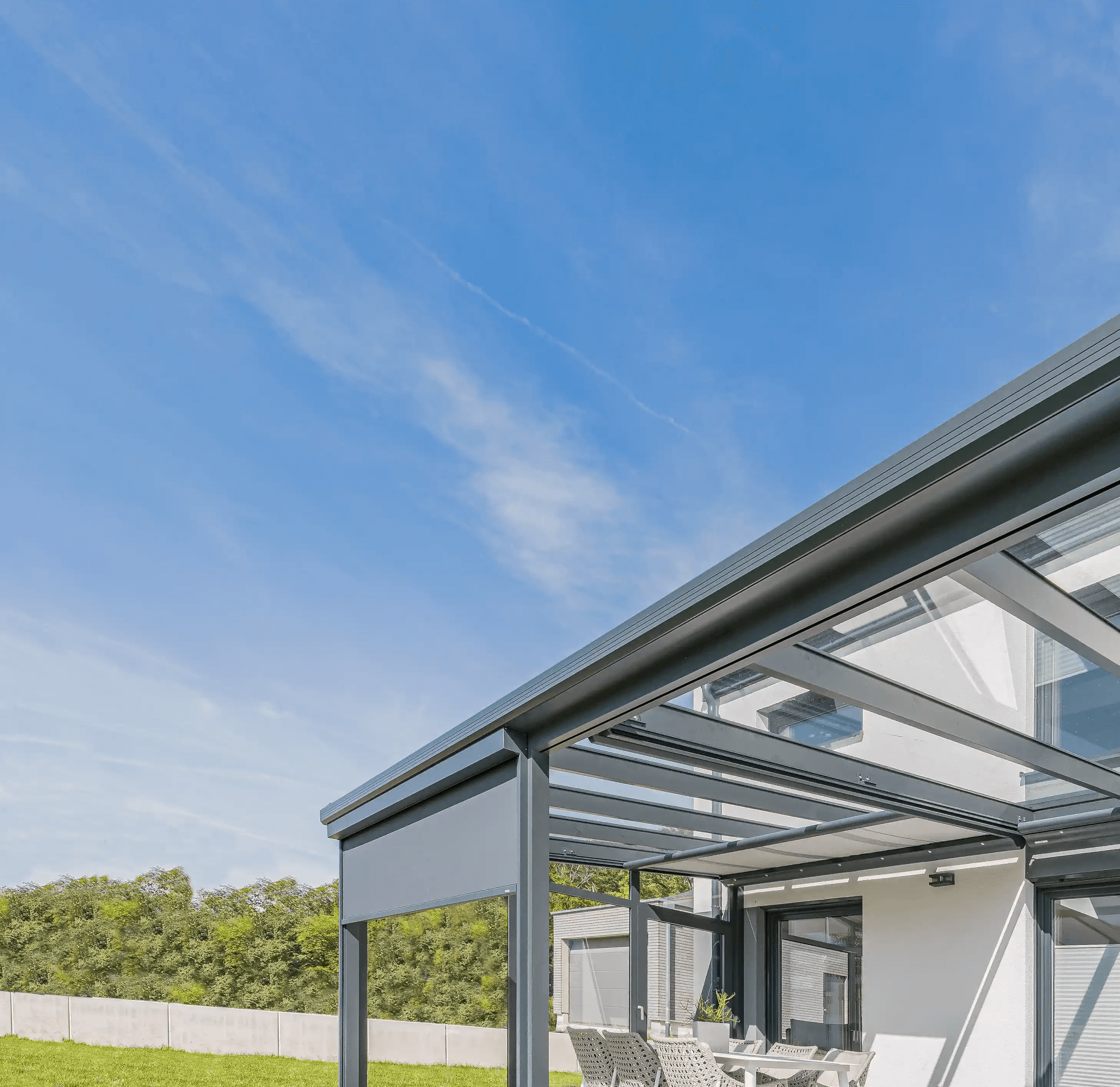 Bild einer Terrassenüberdachung, die bereits teilweise mit Senkrechtmarkise und Seitenwand erweitert wurde