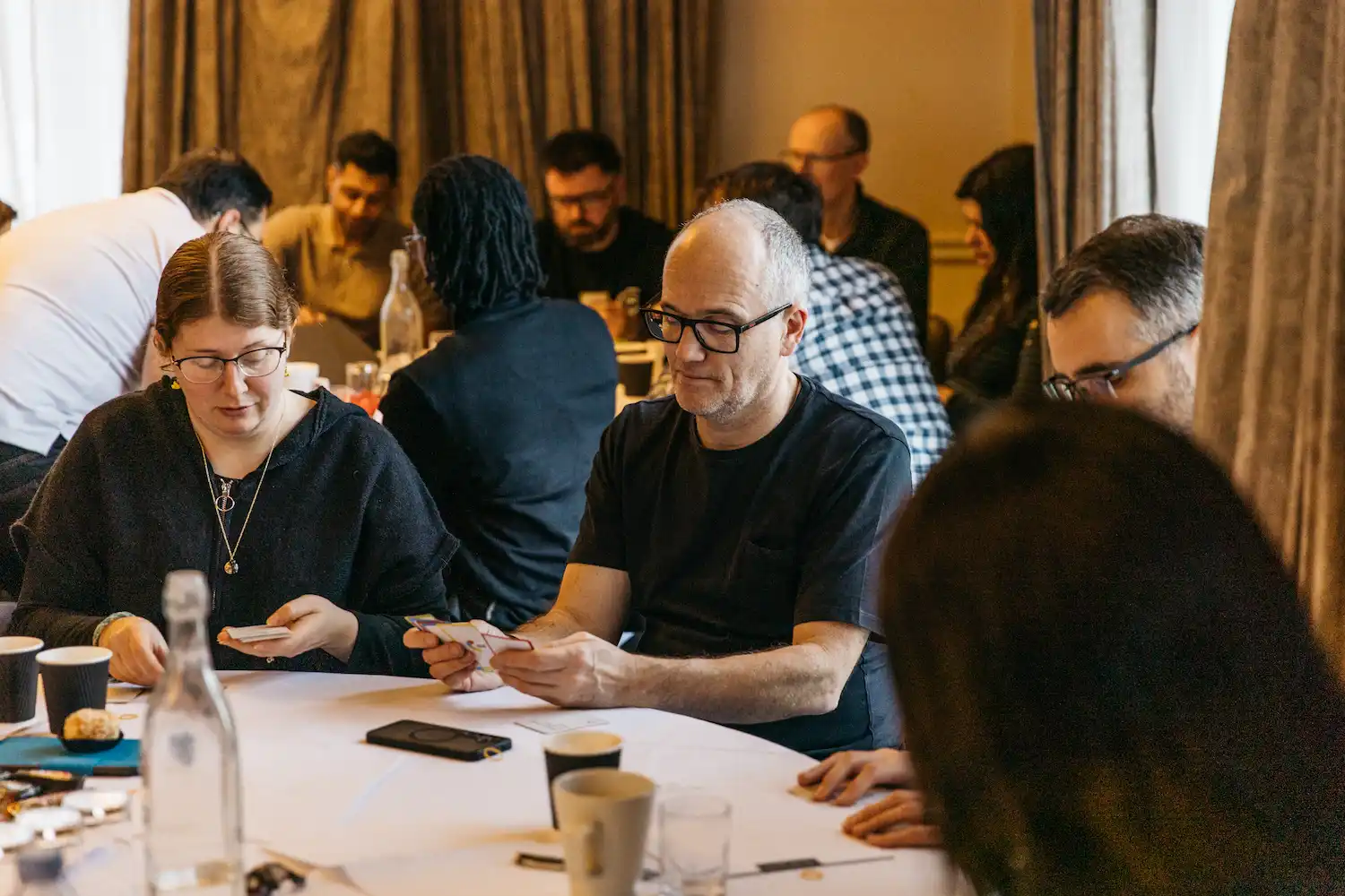 Group of people at a table with cards.