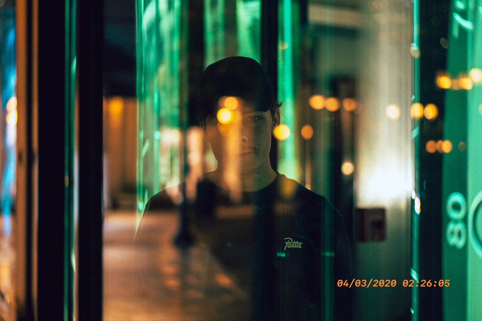 Portrait artistique d'un homme derrière une vitre avec des reflets lumineux à Beverly Hills.