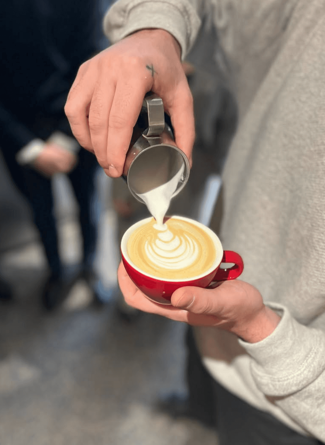 Barista pouring milk into a cup