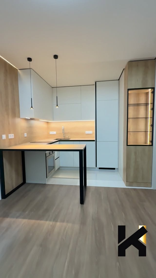Young woman wearing a green striped outfit and patterned cap, carrying a matching green tote bag in a bright indoor setting with plants.