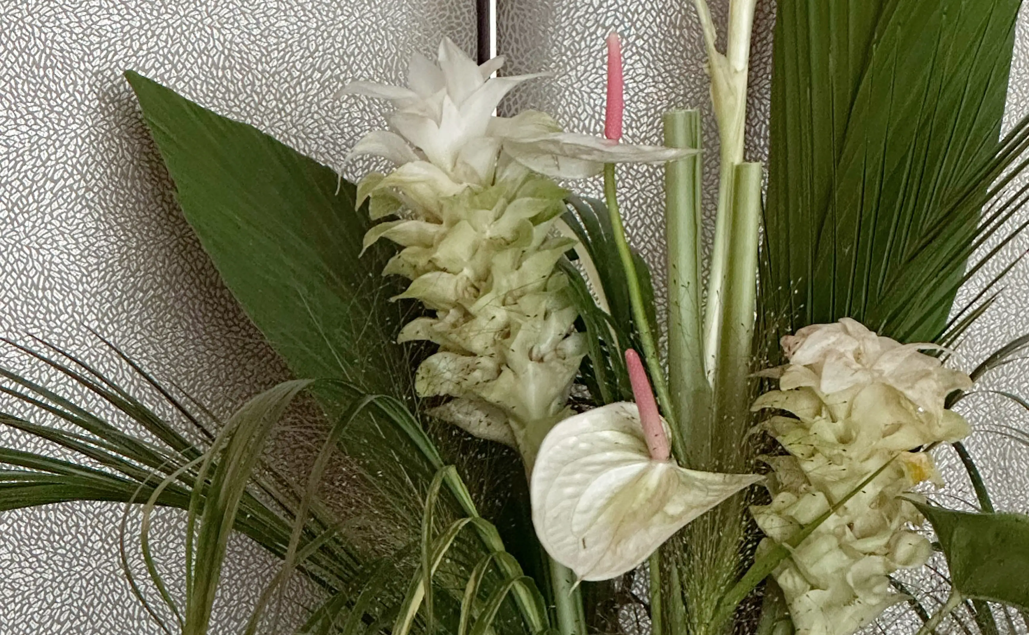 Composición tropical con anthurium y flores blancas para floristas que buscan inspiración en arreglos botánicos exóticos y equilibrados.