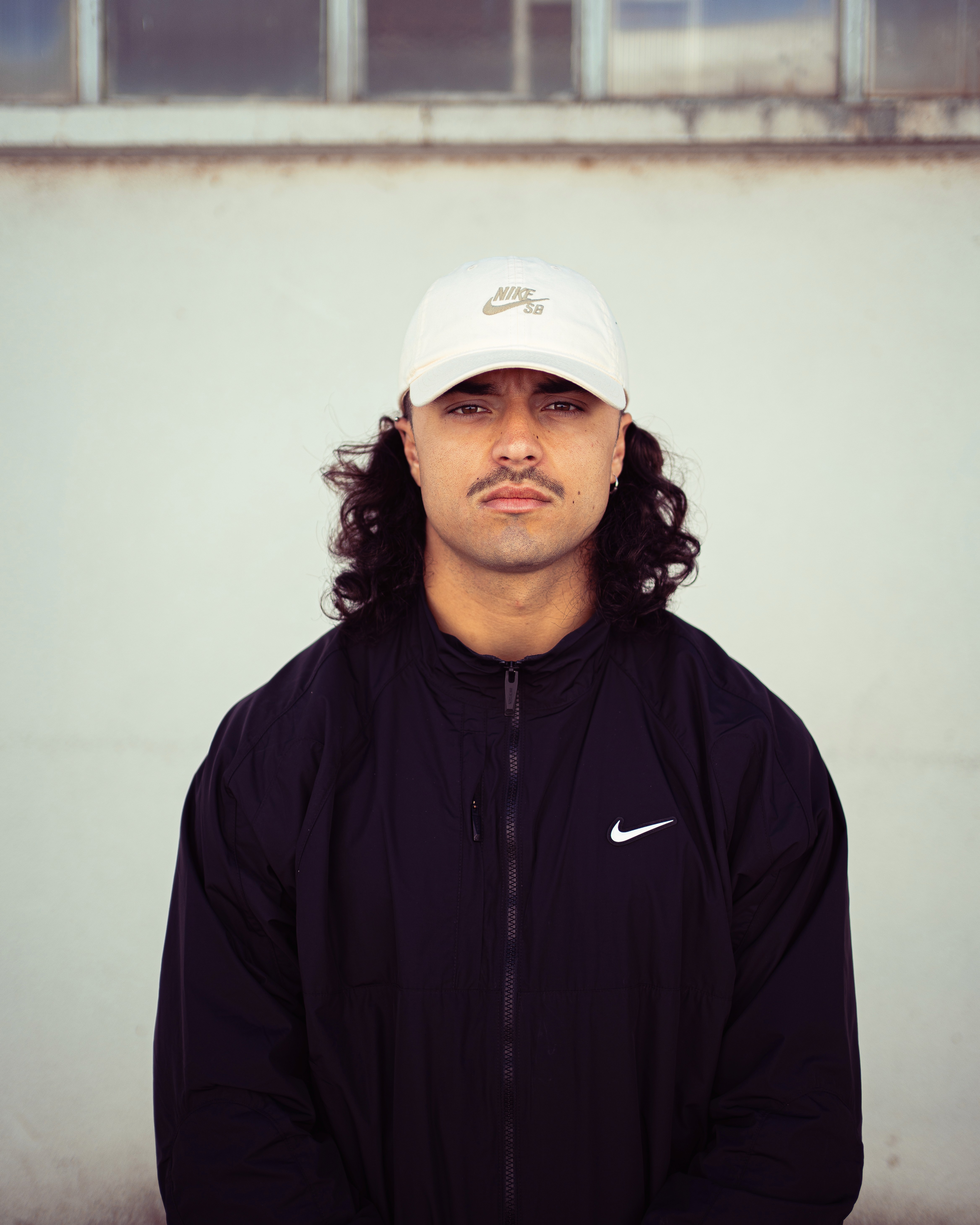 A woman with glasses stands in front of an orange light, creating a warm and inviting atmosphere.