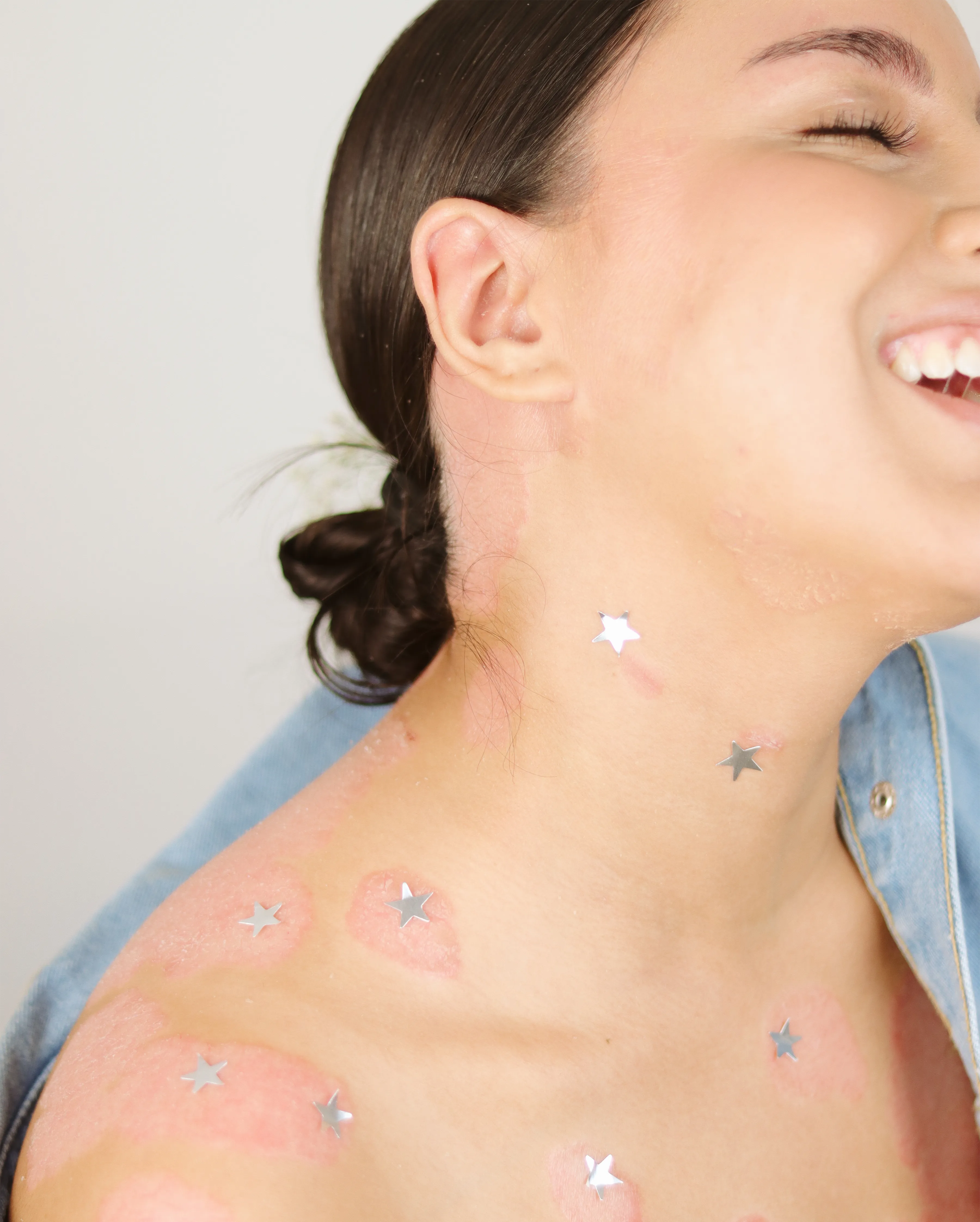 Retrato femenino sonriente con detalles de estrellas en la piel