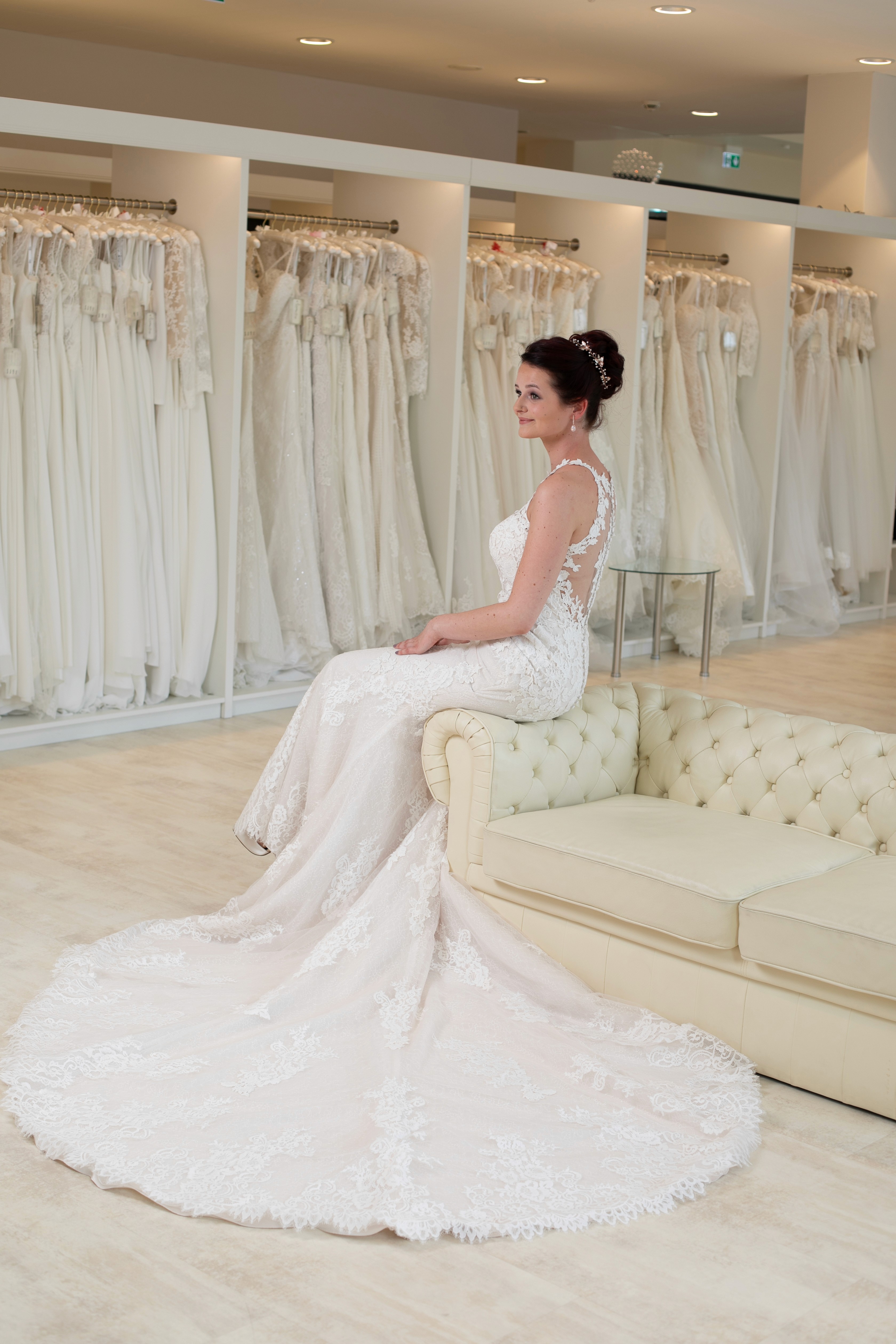 Dynamische Brautmode-Inszenierung - elegantes Brautkleid in schwungvoller Bewegung auf historischer Treppe, Model mit ausdrucksstarkem Blick zur Kamera