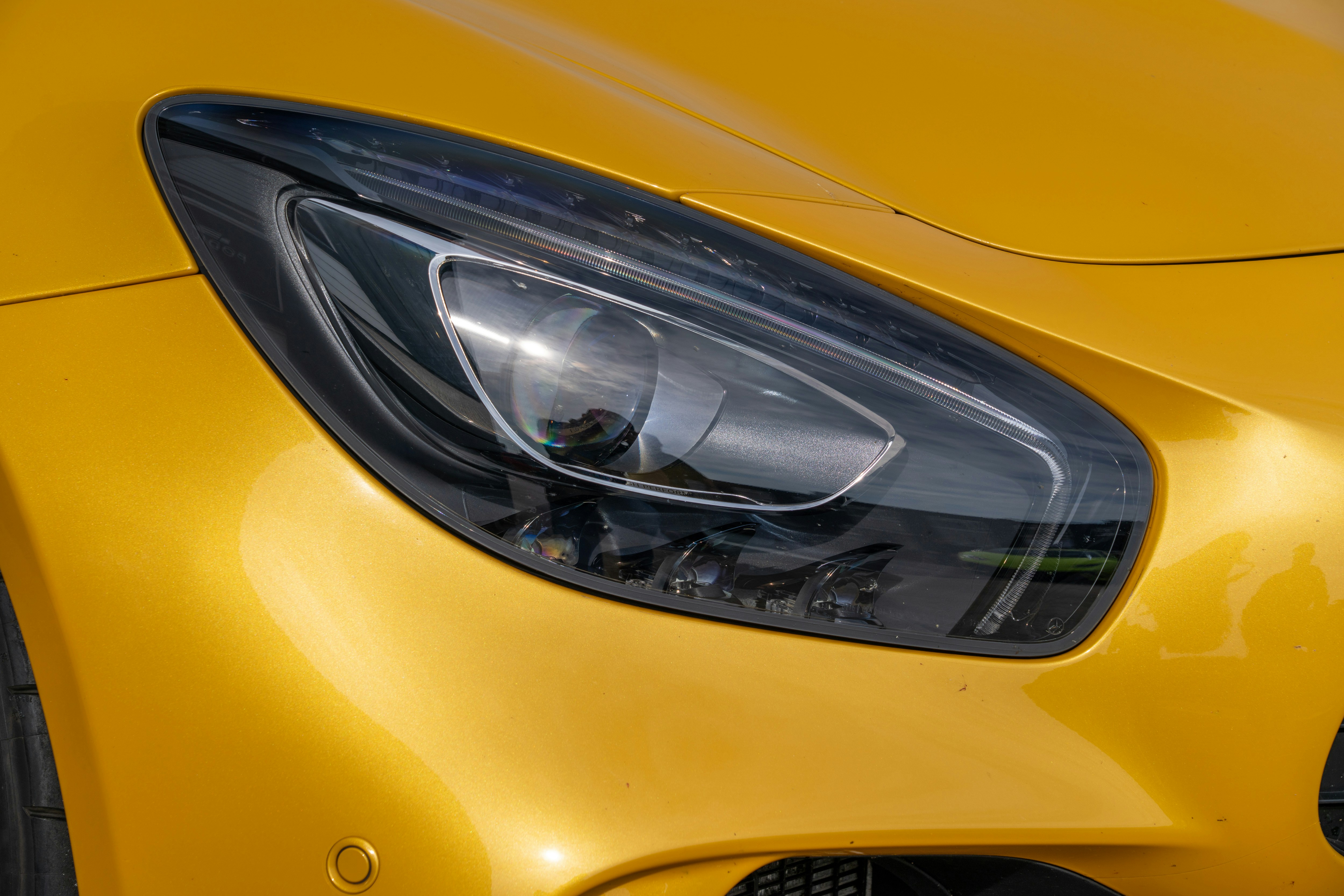 Close-up of a yellow sports car headlight.