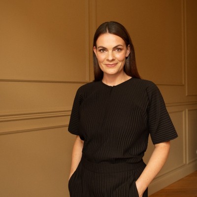 A person in a blue coat smiling