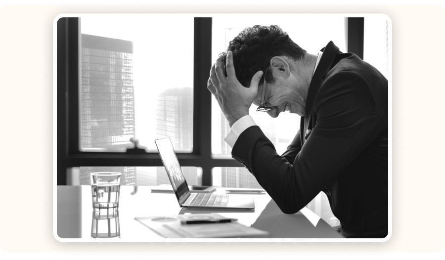 A stressed man sitting in front of a laptop