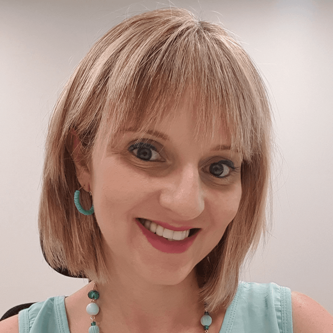 Woman with freckles and a black turtleneck.