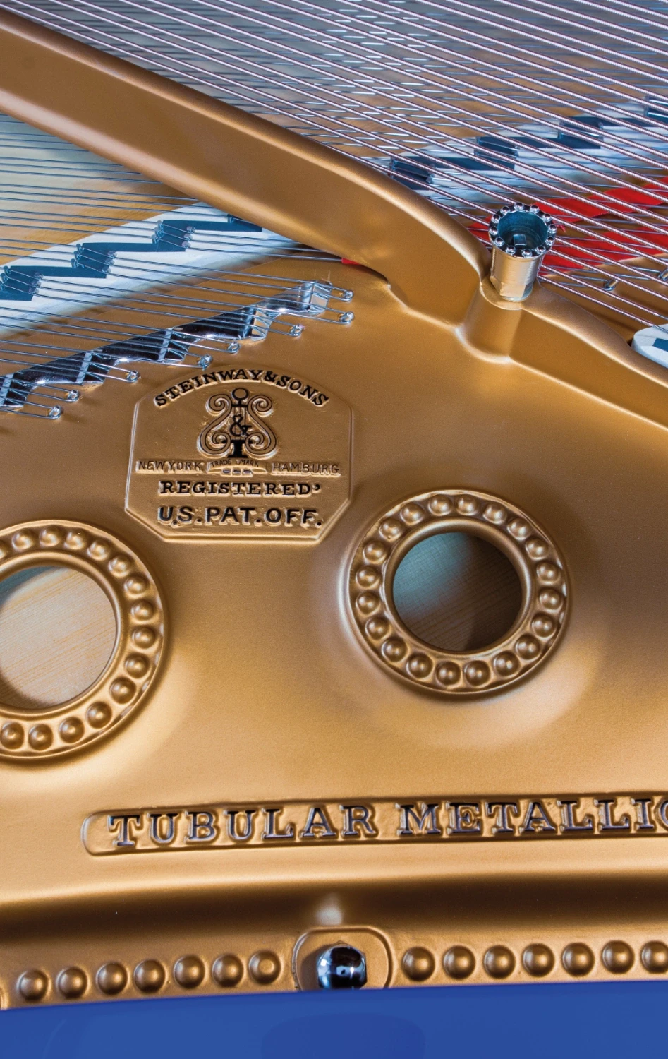 A beautifully restored piano interior, where the golden iron frame meets finely crafted wooden elements.