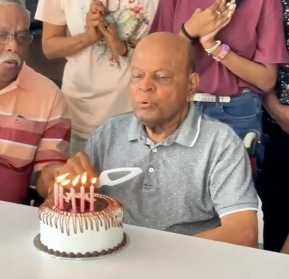 A male senior celebrating his birthday with his family and other Golden Oak's residents at Golden Oaks elder care home.