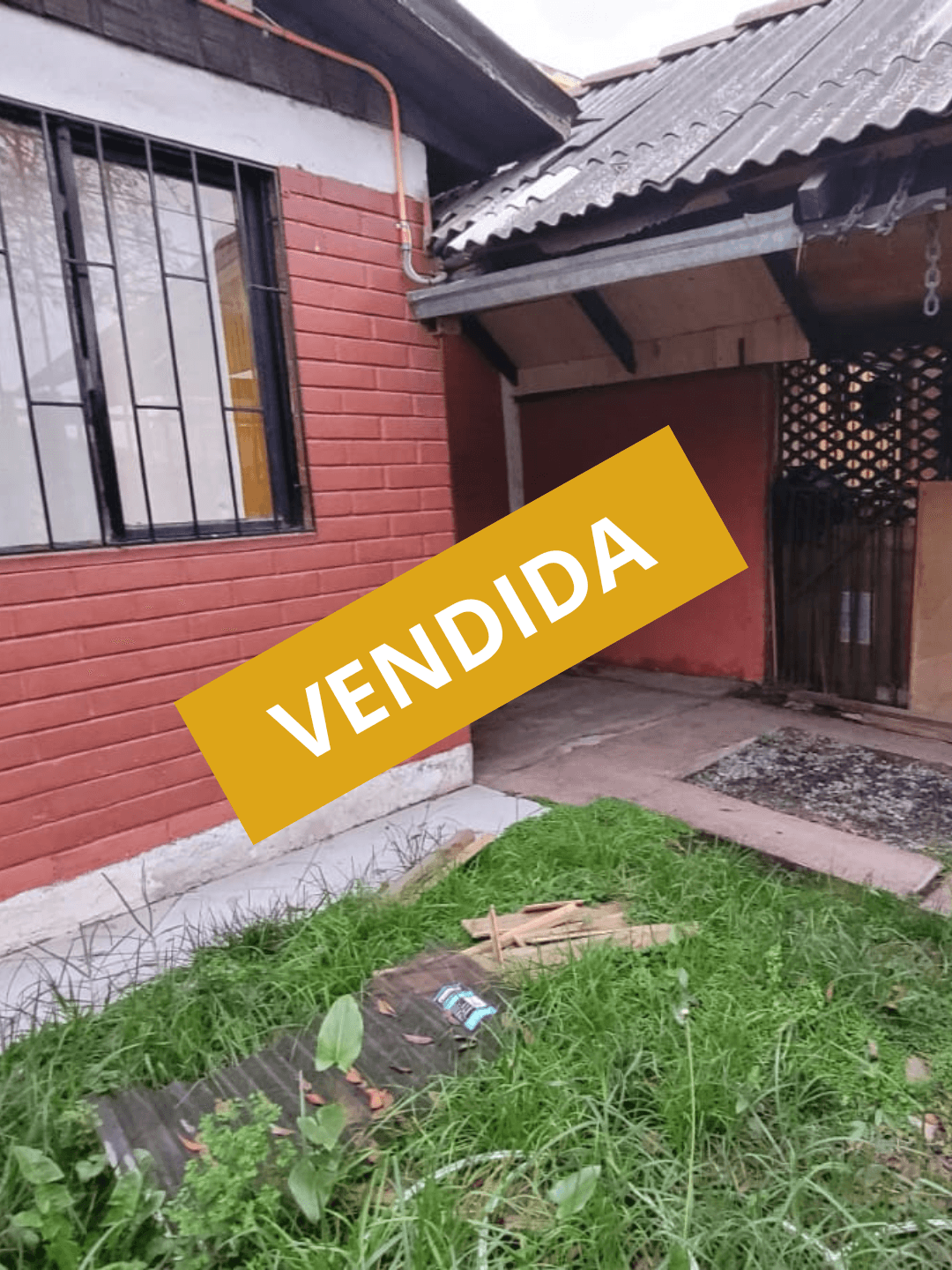 Red wooden harbor house overlooking boats, water, and snow-capped mountains.
