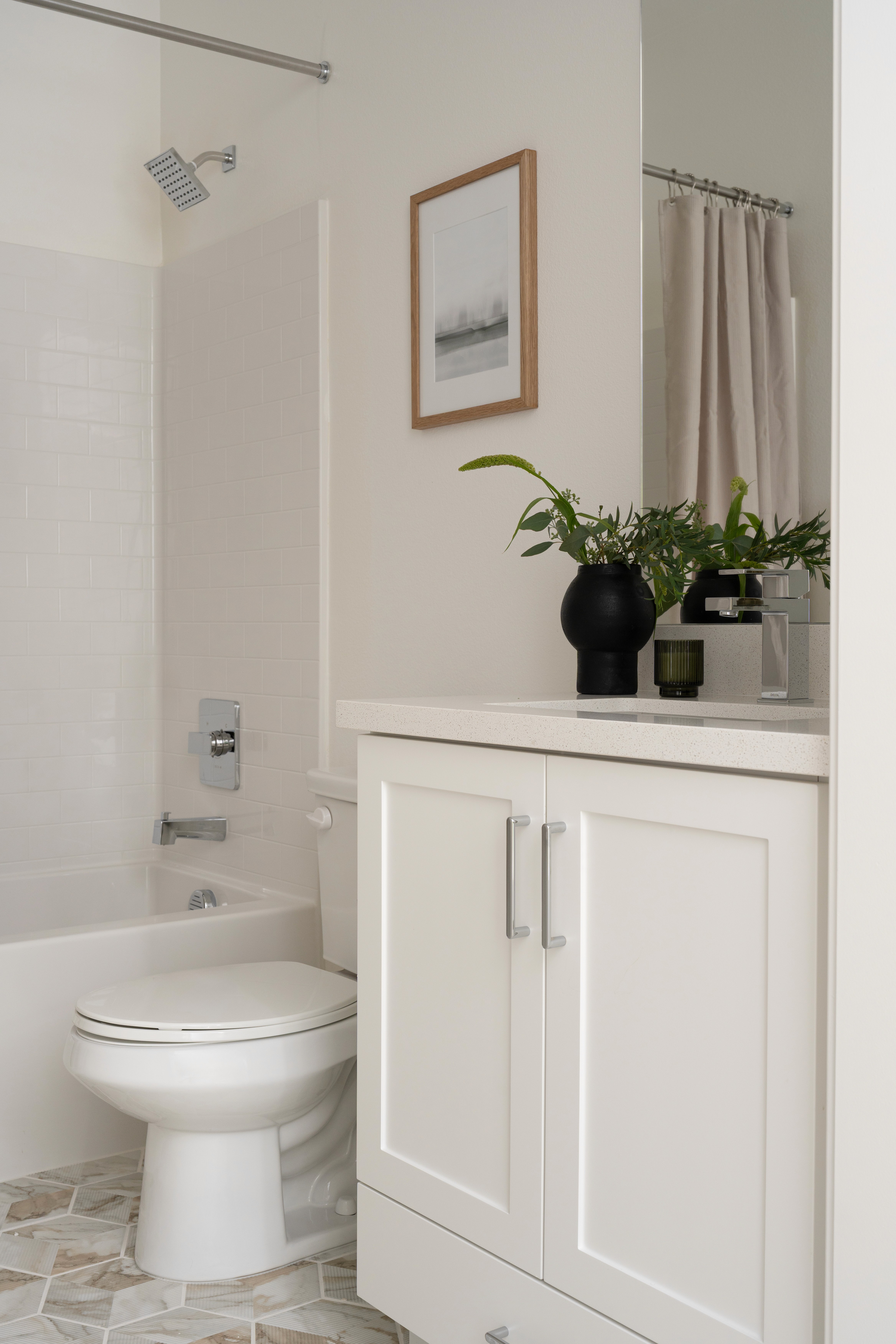 Guest bathroom with artwork and greenery