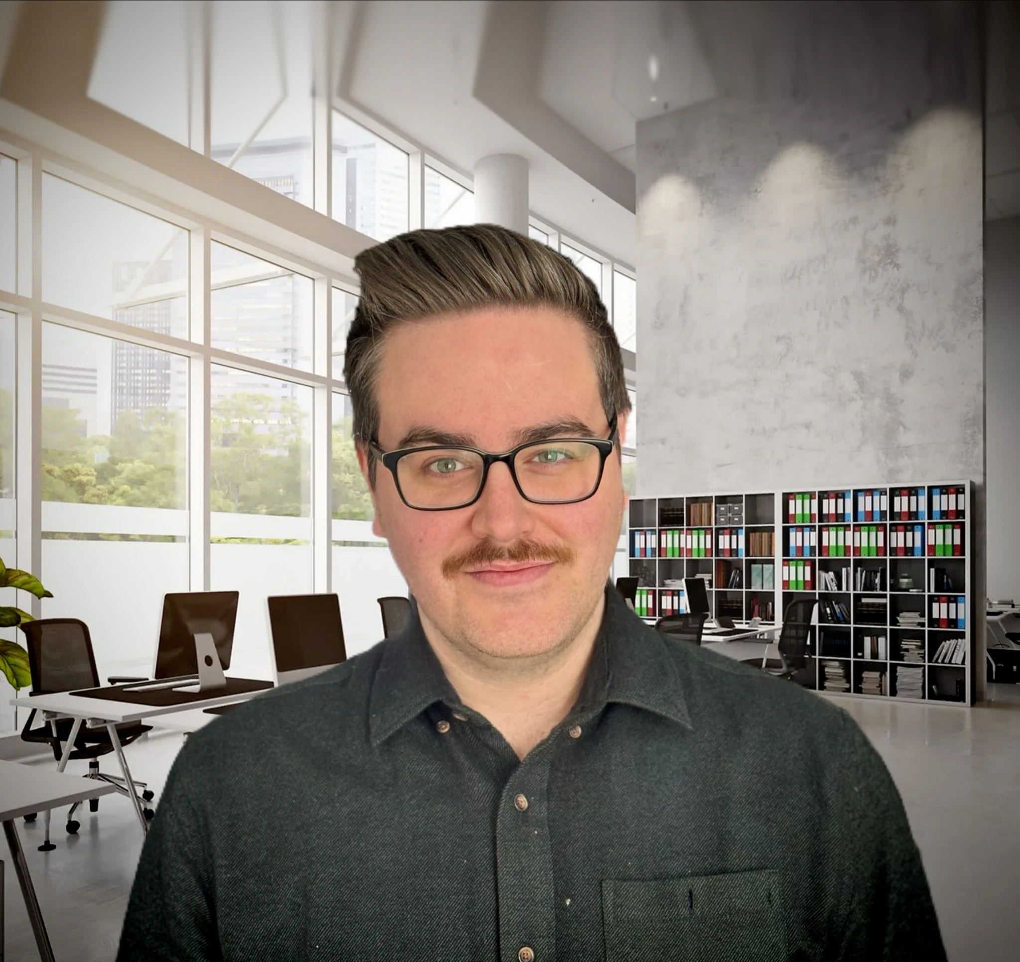 Man with a moustache wearing a dark green button down, short brown hair with glasses.