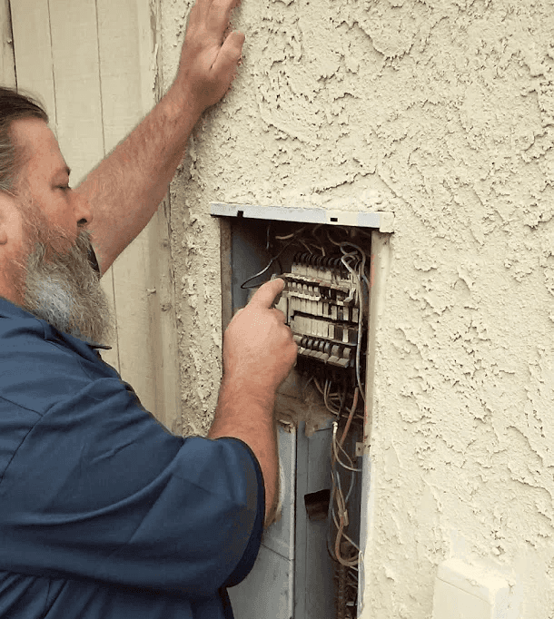 Electrician inspecting and repairing an electrical panel