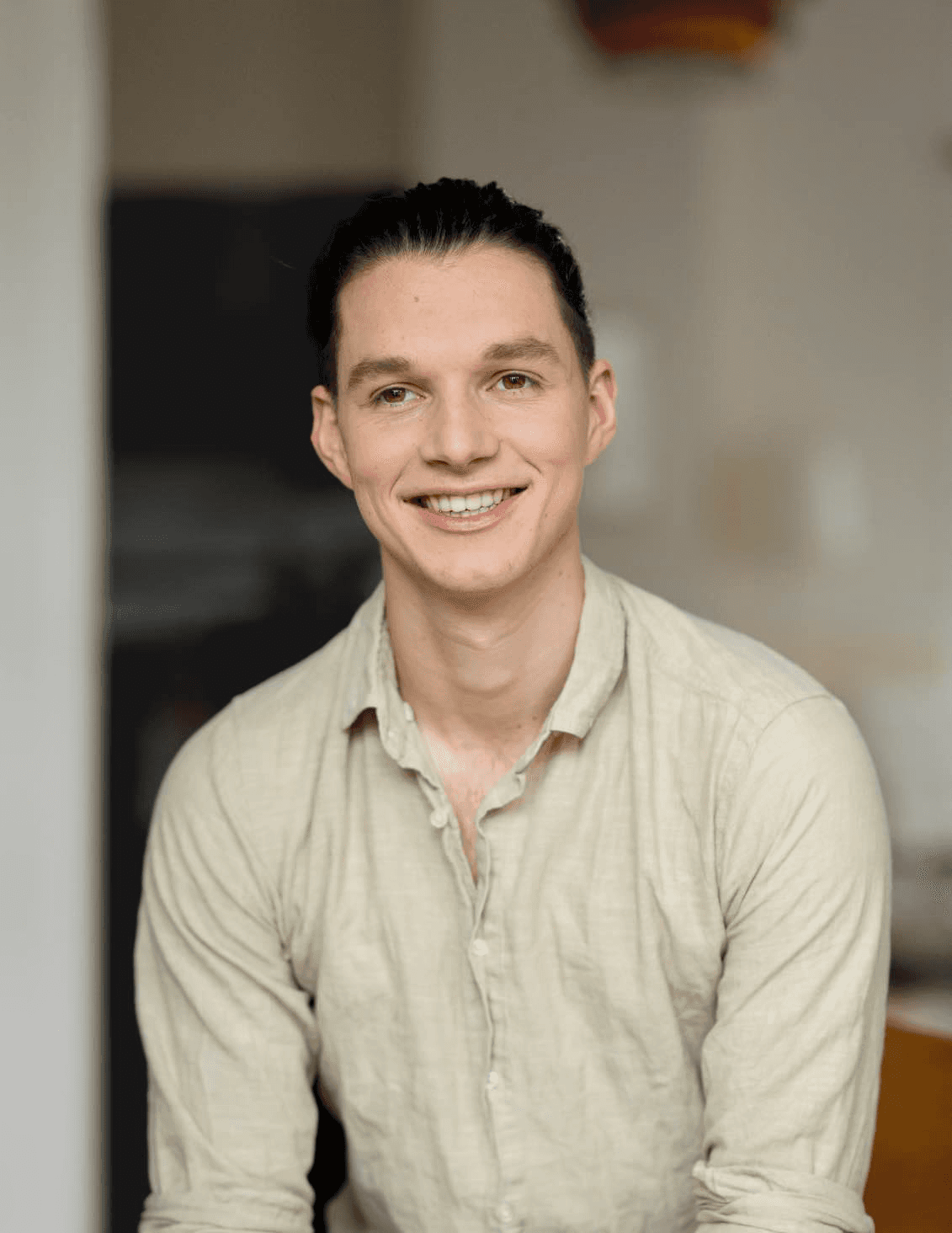 Smiling person seated indoors — founder of Seven Life Areas, offering guidance for living with clarity, harmony, and purpose.