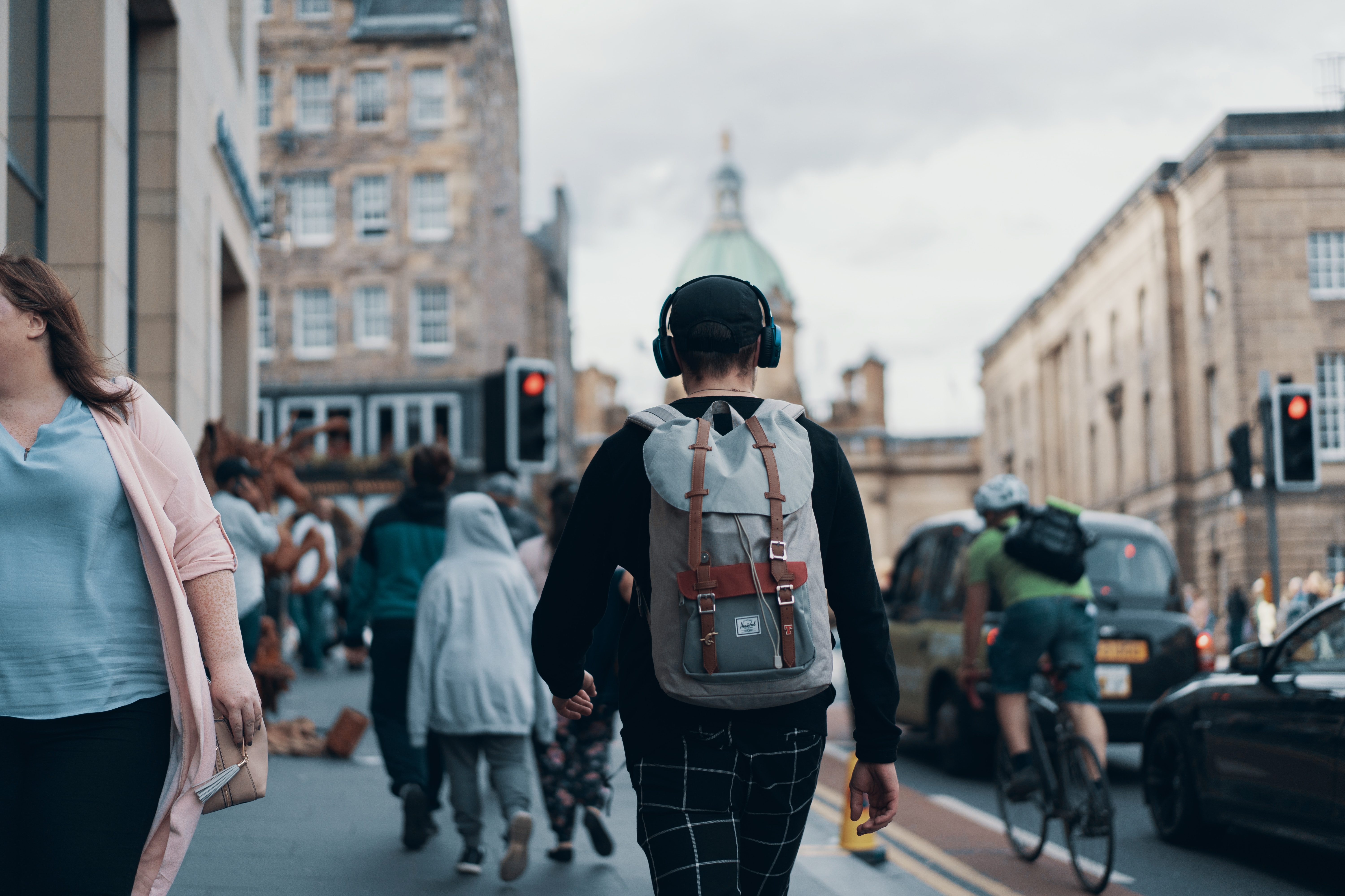 man walking on busy street while listening to best AI songs