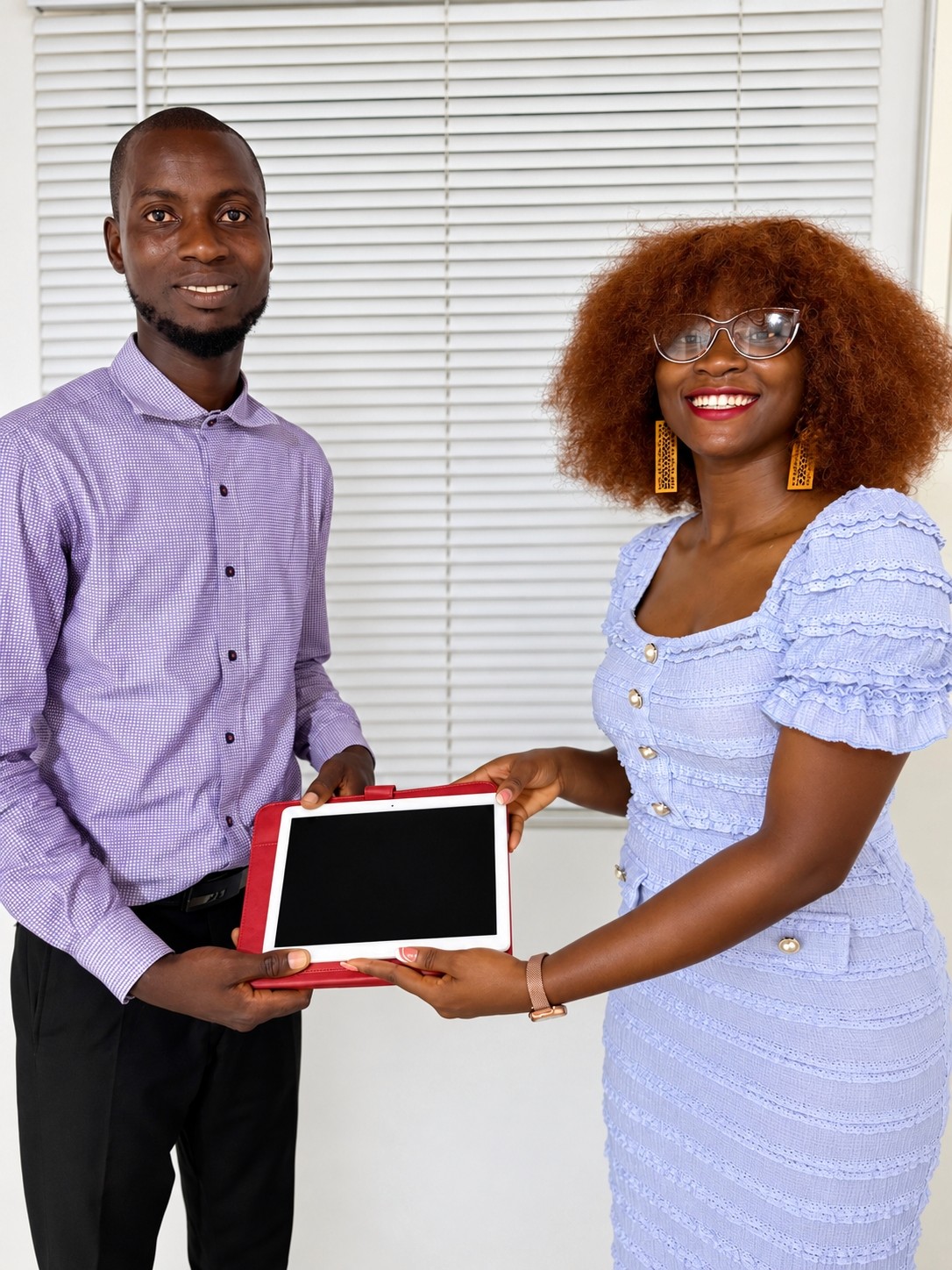 Standout Foundation Executive Director Faith Ememodo presents a prize to 2026 Teacher Impact Story Challenge winner Renneh Sanyang.