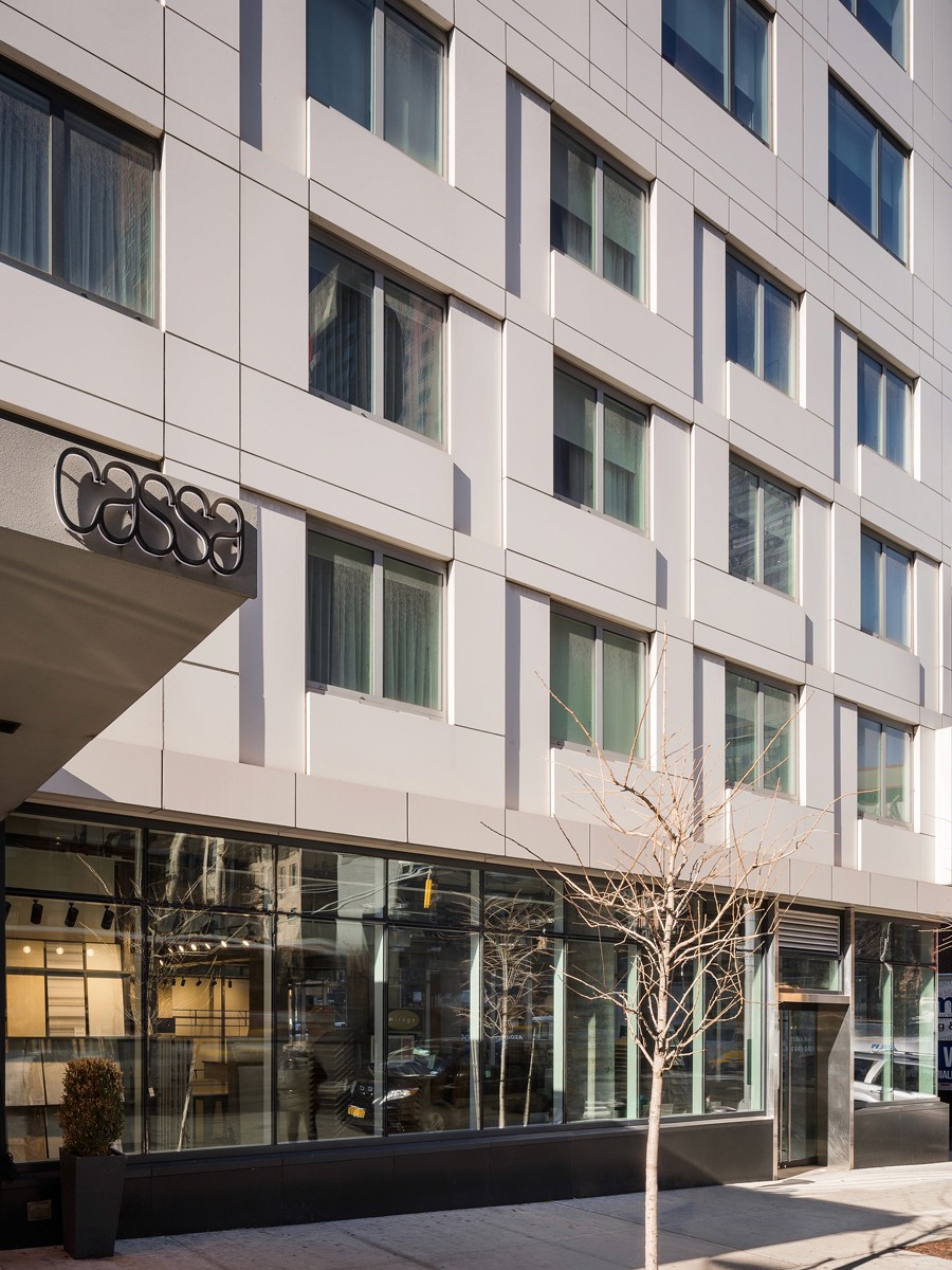 Restored brick building with arched windows and modern glass storefront on a quiet street