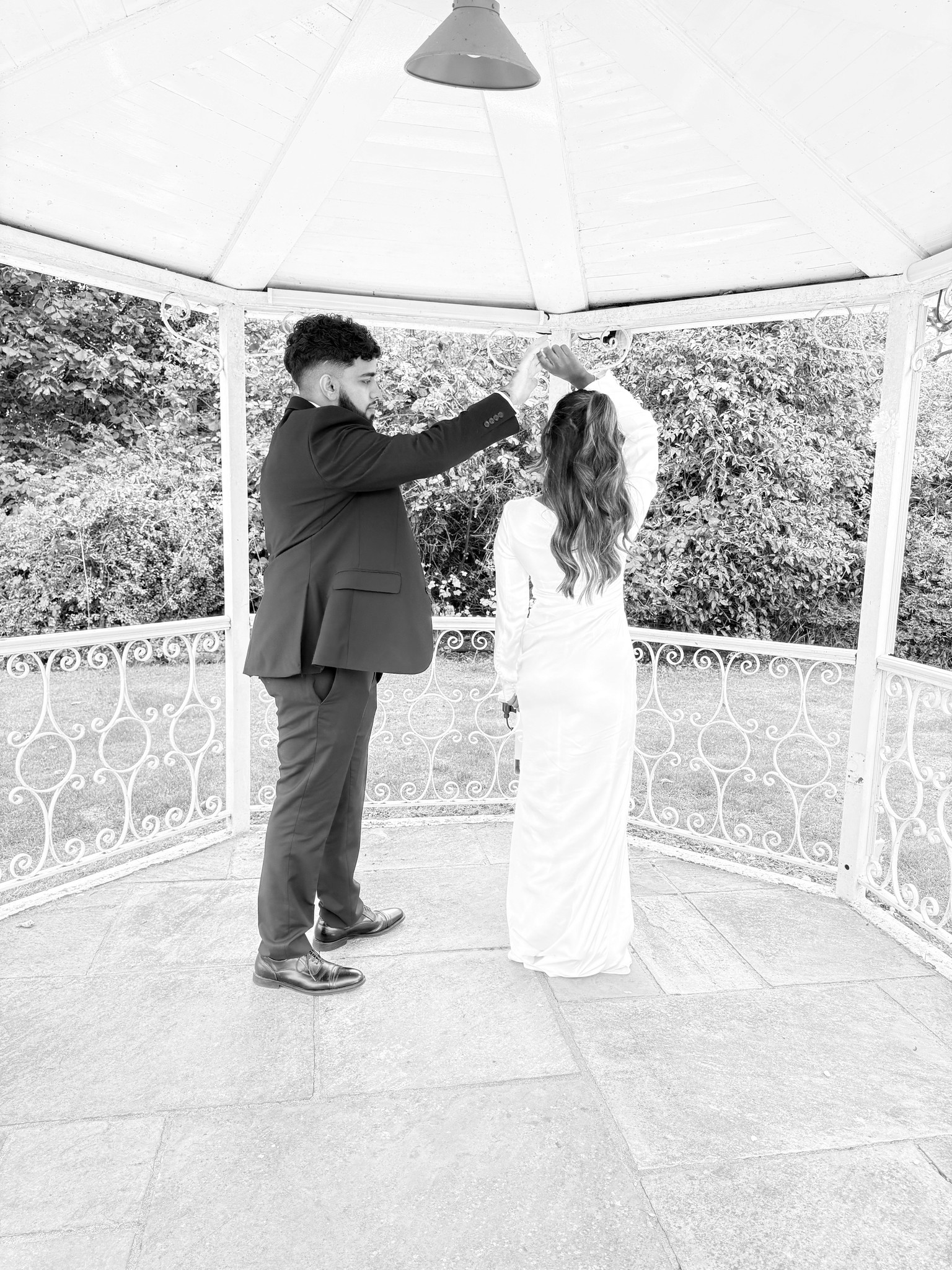 A couple dances closely, showcasing a flowing green dress, against a soft, blurred background of other guests.