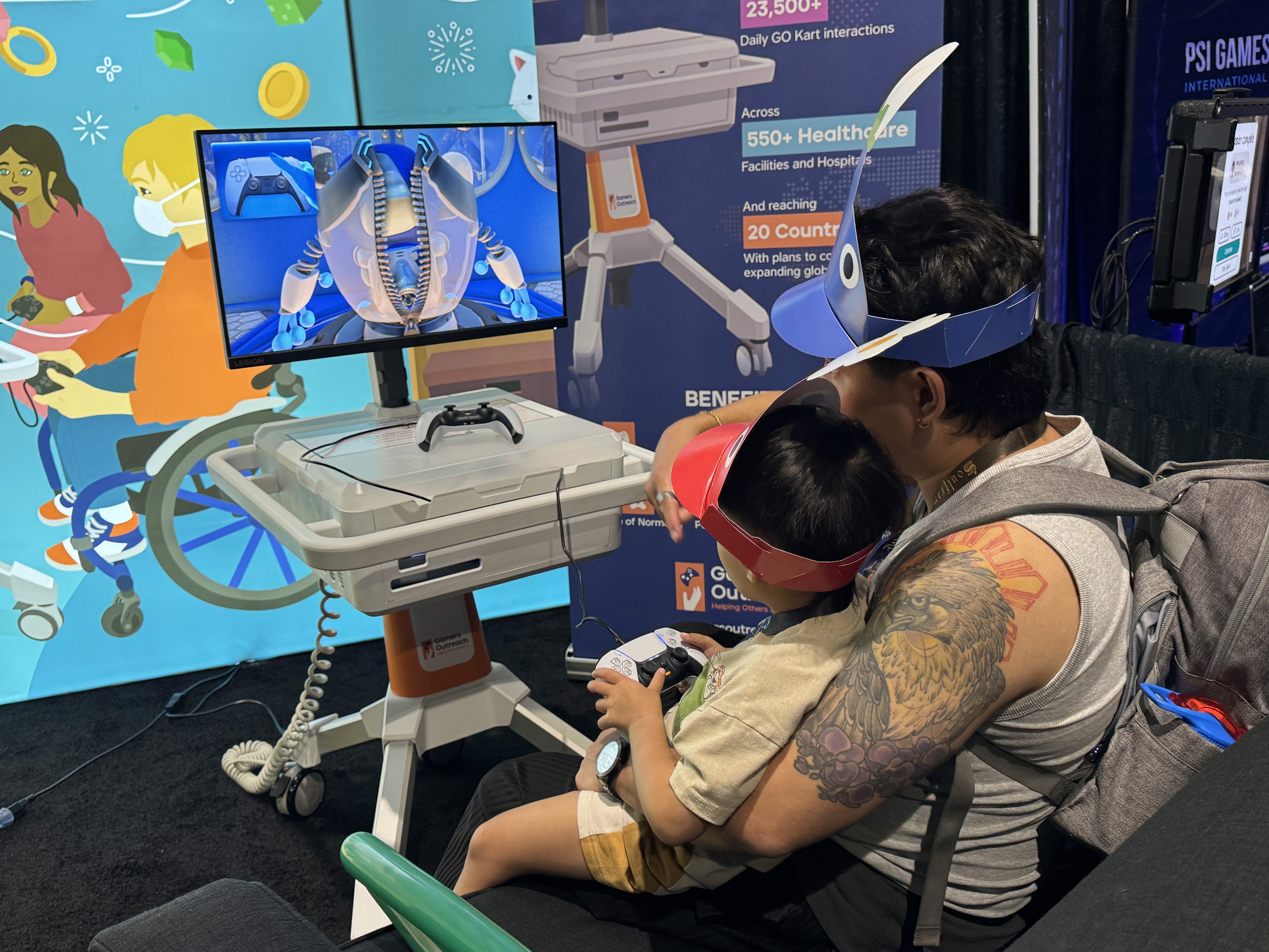A father and son in Pikmin hats play on a GO Kart at PAX West.
