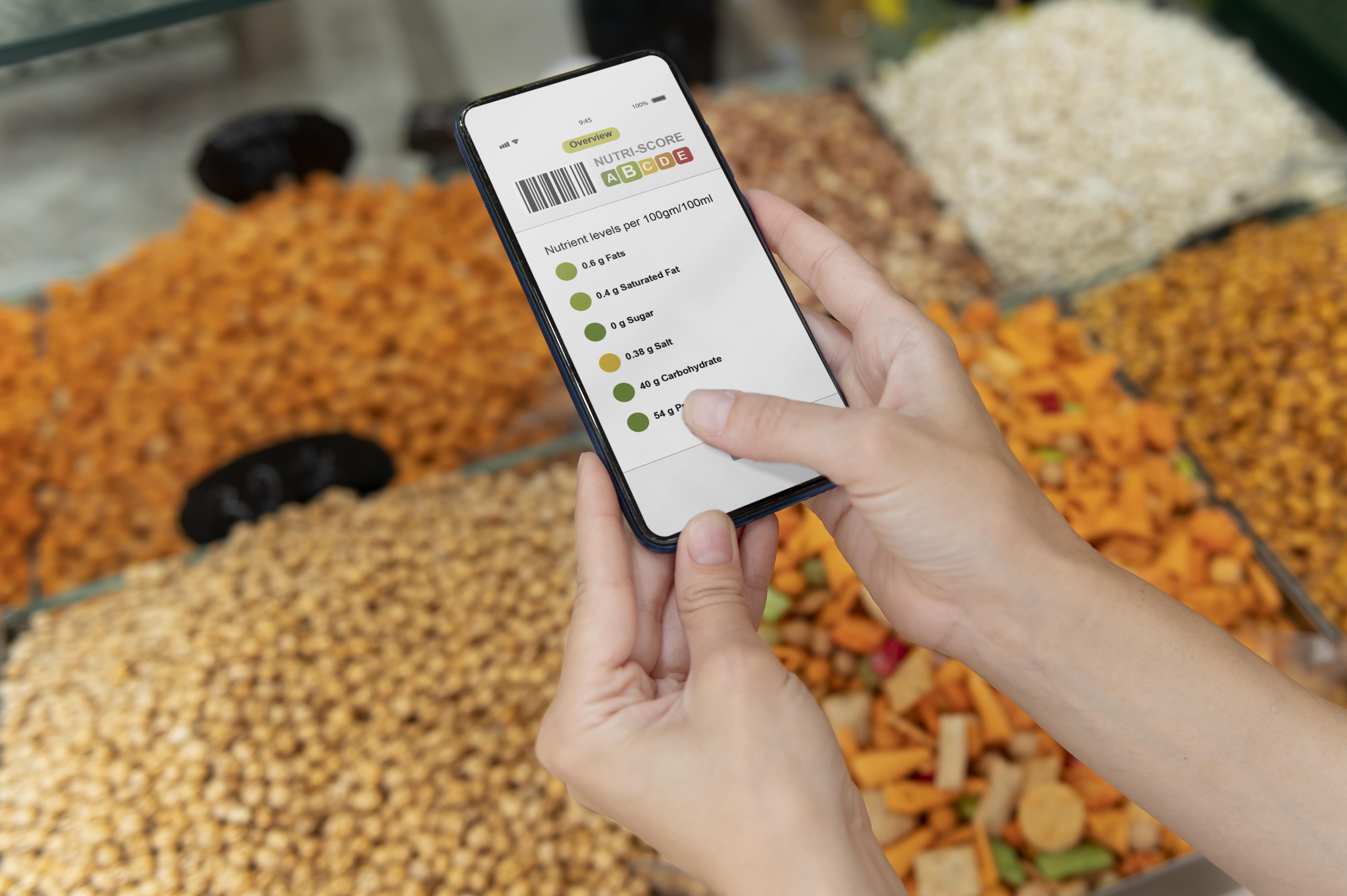 women checking food products through barcode scanner in app