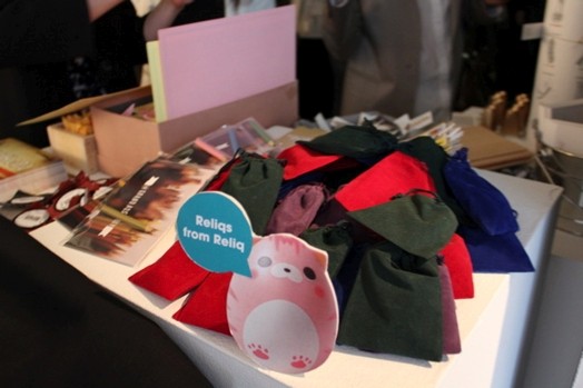 a table with a pile of fabric objects and flyers