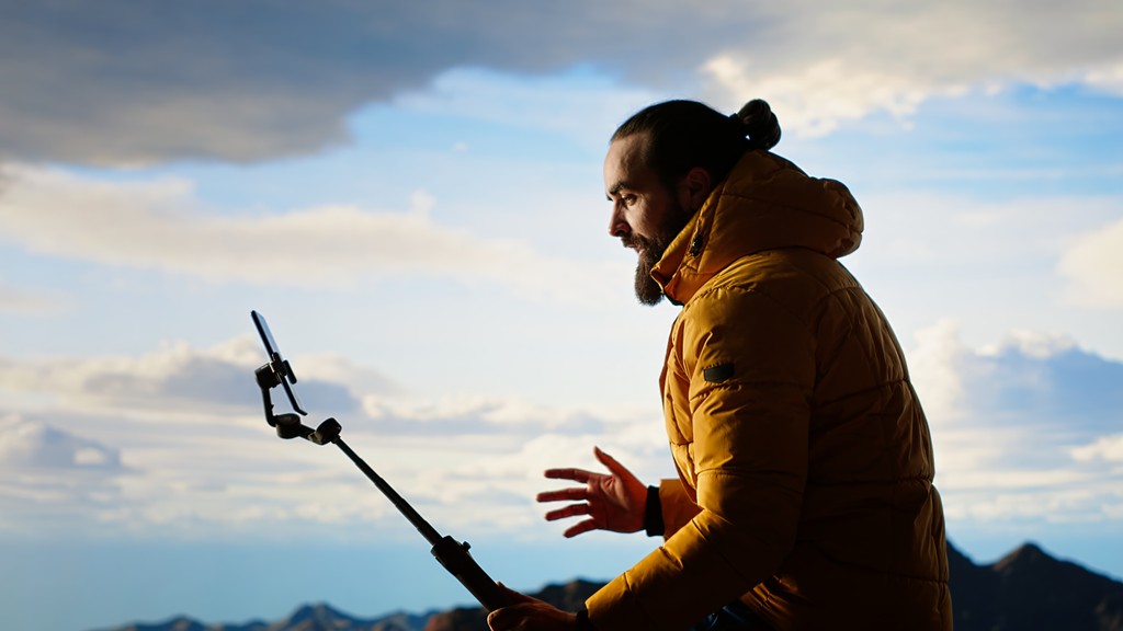 Content creator filming outdoors at sunset with gimbal for social media platform