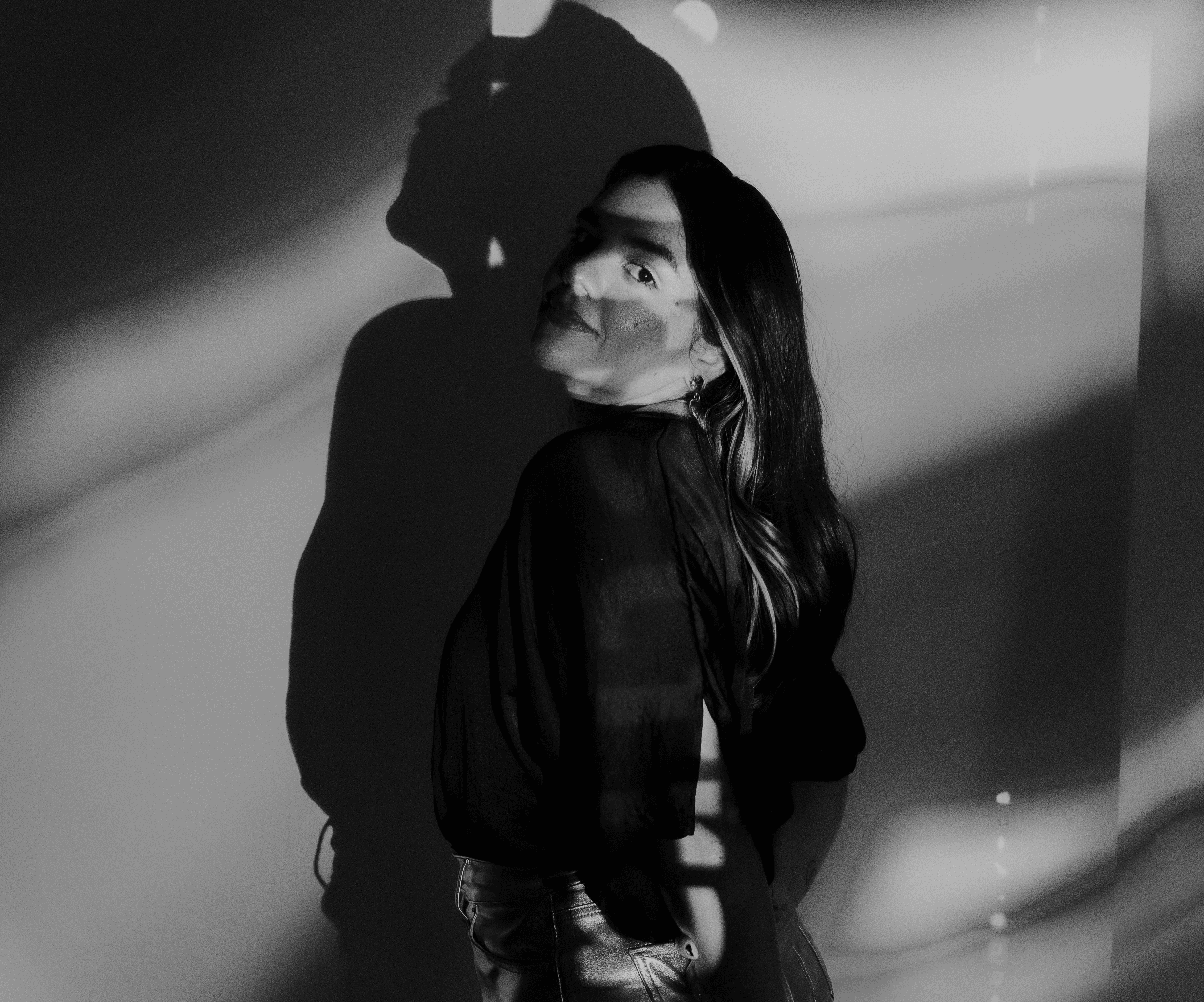 Black and white image of people working at a table with laptops, showing hands gesturing during discussion of digital content displayed on screens, with fabrica® logo in the corner.