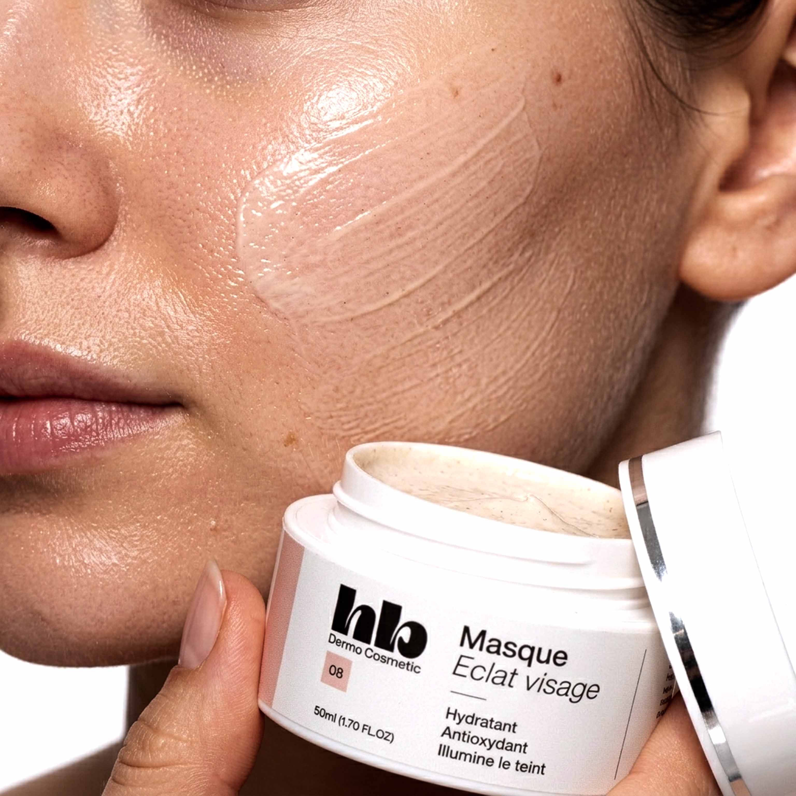 manenquin avec un pot de soin pour le visage et du soin étalé sur sa joue