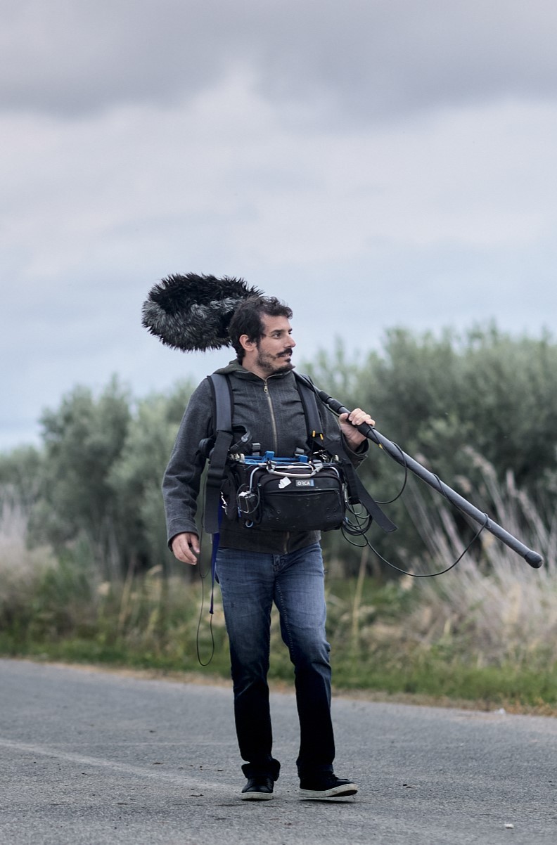 Manolis Makridakis carrying boom microphone and field recording equipment on location in Greece
