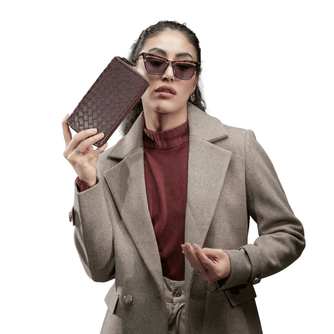 Woman holding a woven brown wallet against a white background