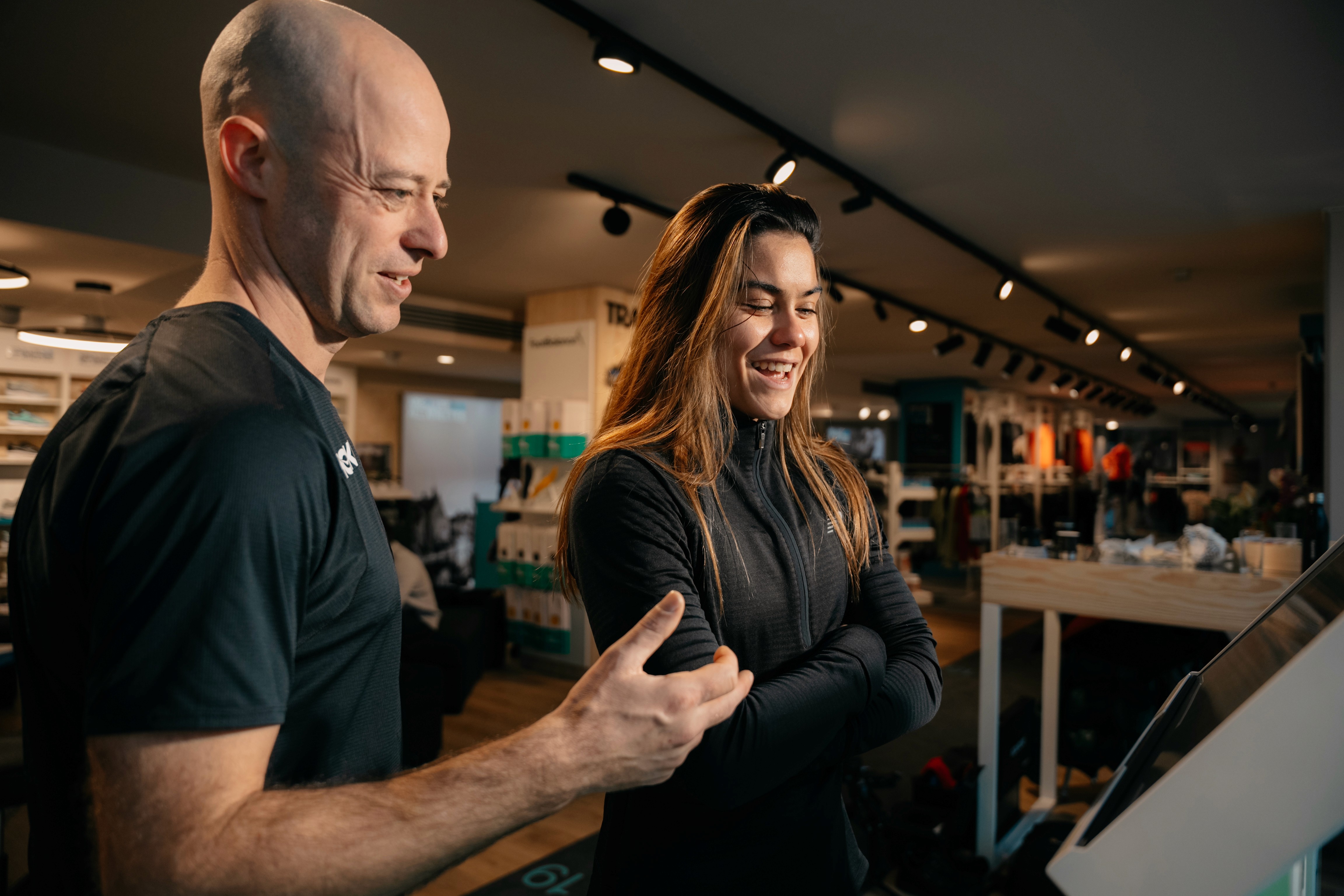 Four diverse professionals collaboratively working on a laptop, with one person pointing at the screen while others observe.