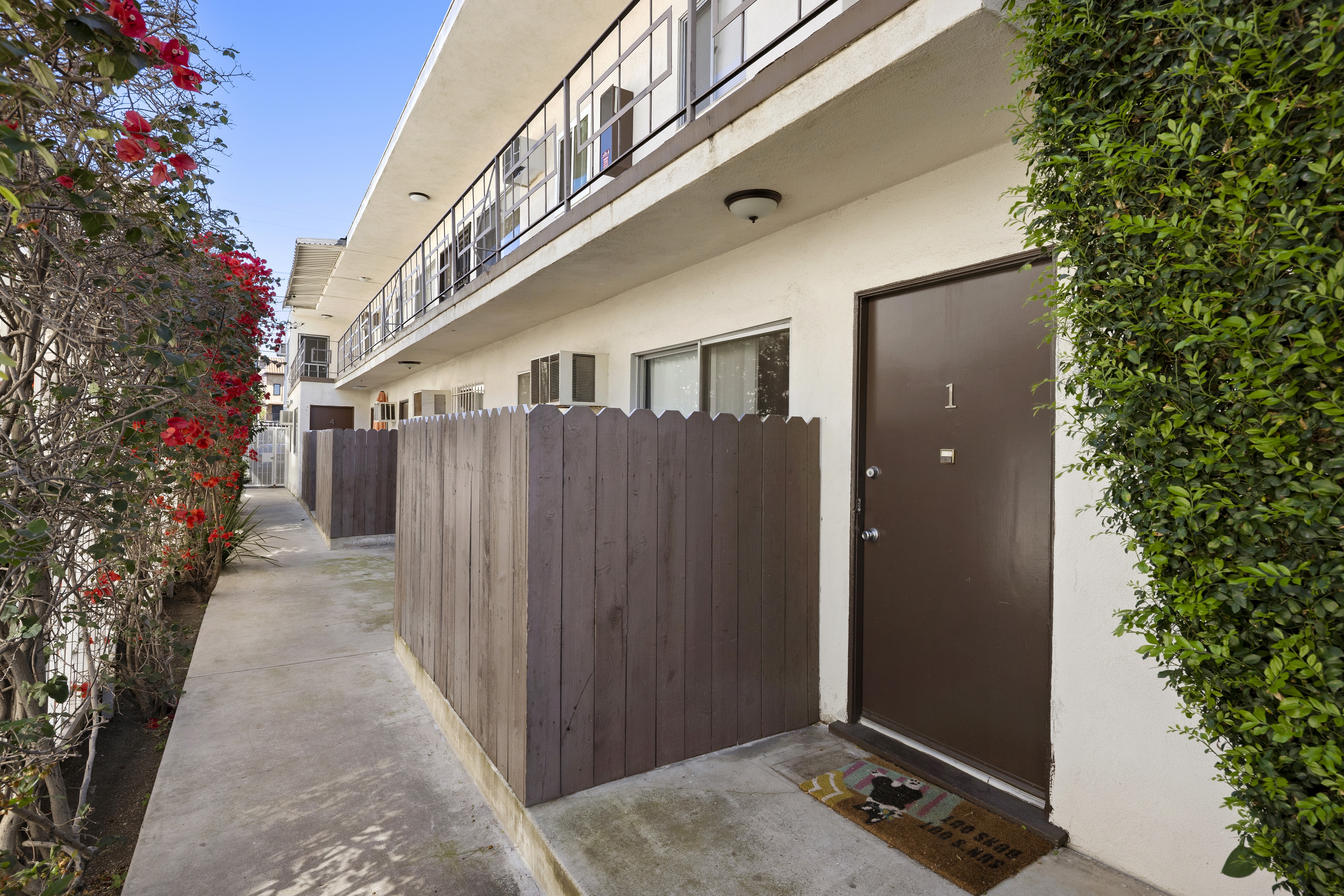 Ground-level walkway with unit entrance and private patio fencing at 1336 N Citrus Ave.