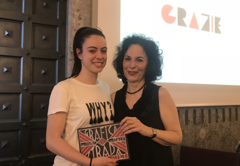 A photo of two women holding an art notebook.