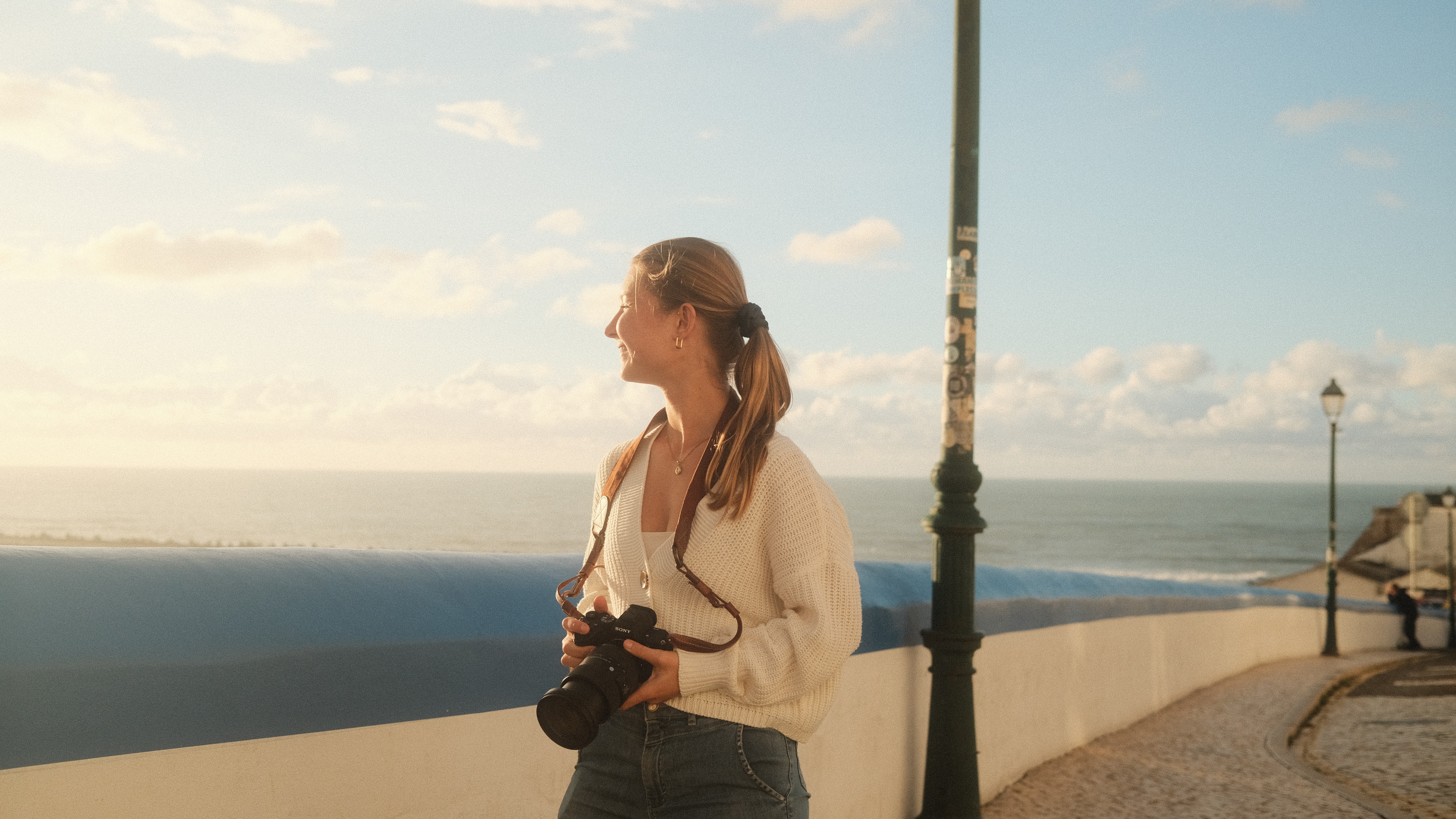 Girl with camera looking out to the ocean