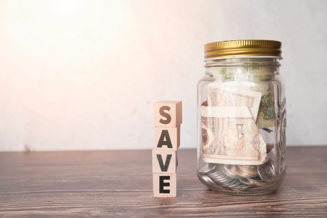 A jar filled with money against a 'save' background, representing cost savings from quitting alcohol.