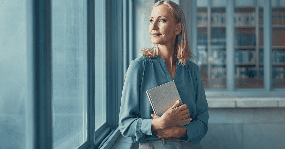 Wellness seeker holding a notebook by a window