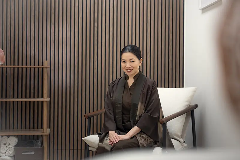 The owner of En Beauty sits in a char wearing a tradittional Japanese Kimono