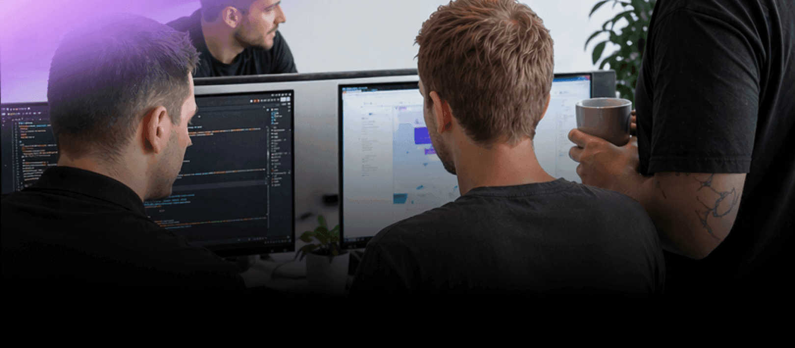 Nextio developers collaborating on custom software development and coding a web application on dual monitors.