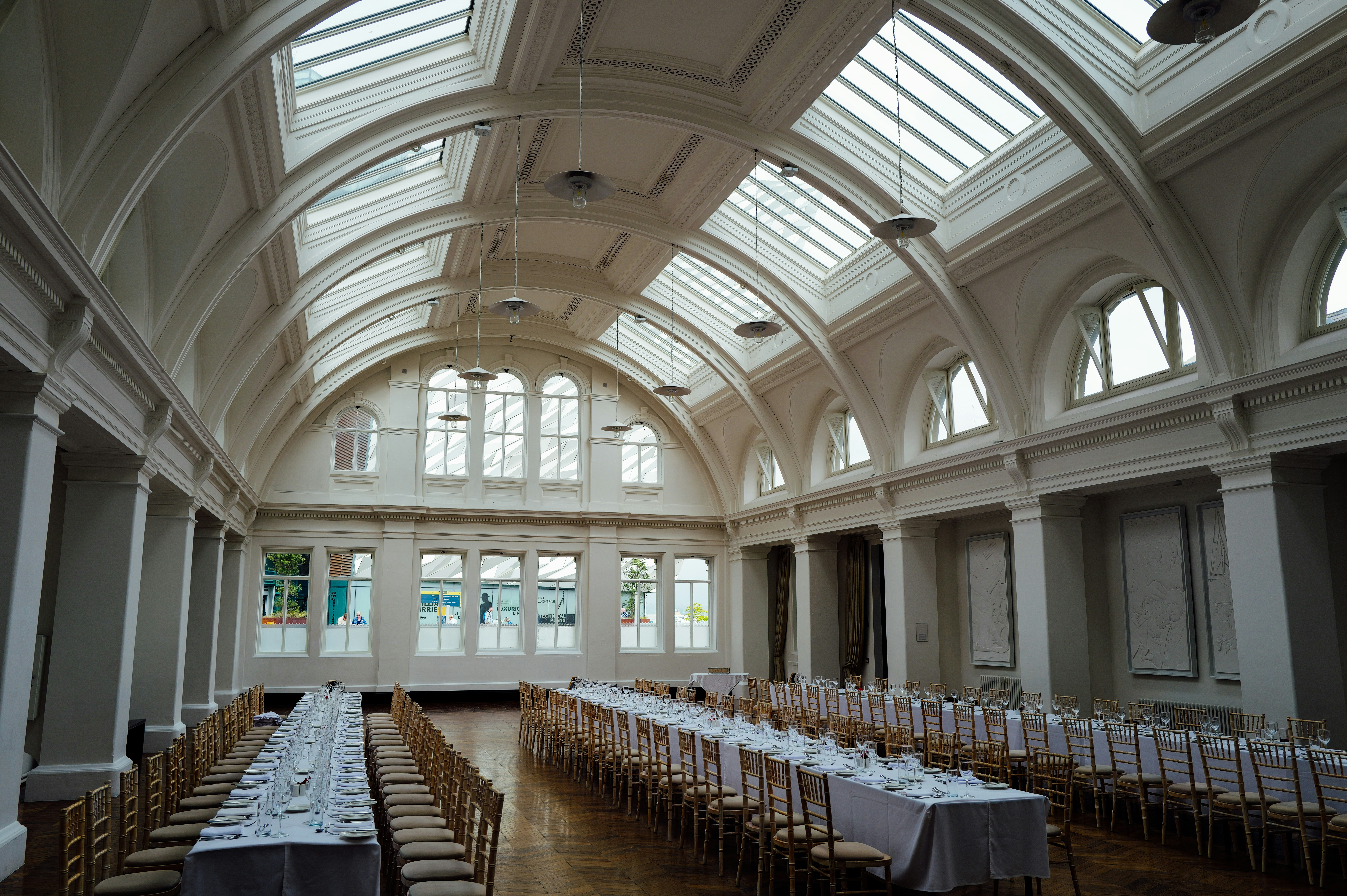 Long tables set for a banquet in a grand hall.