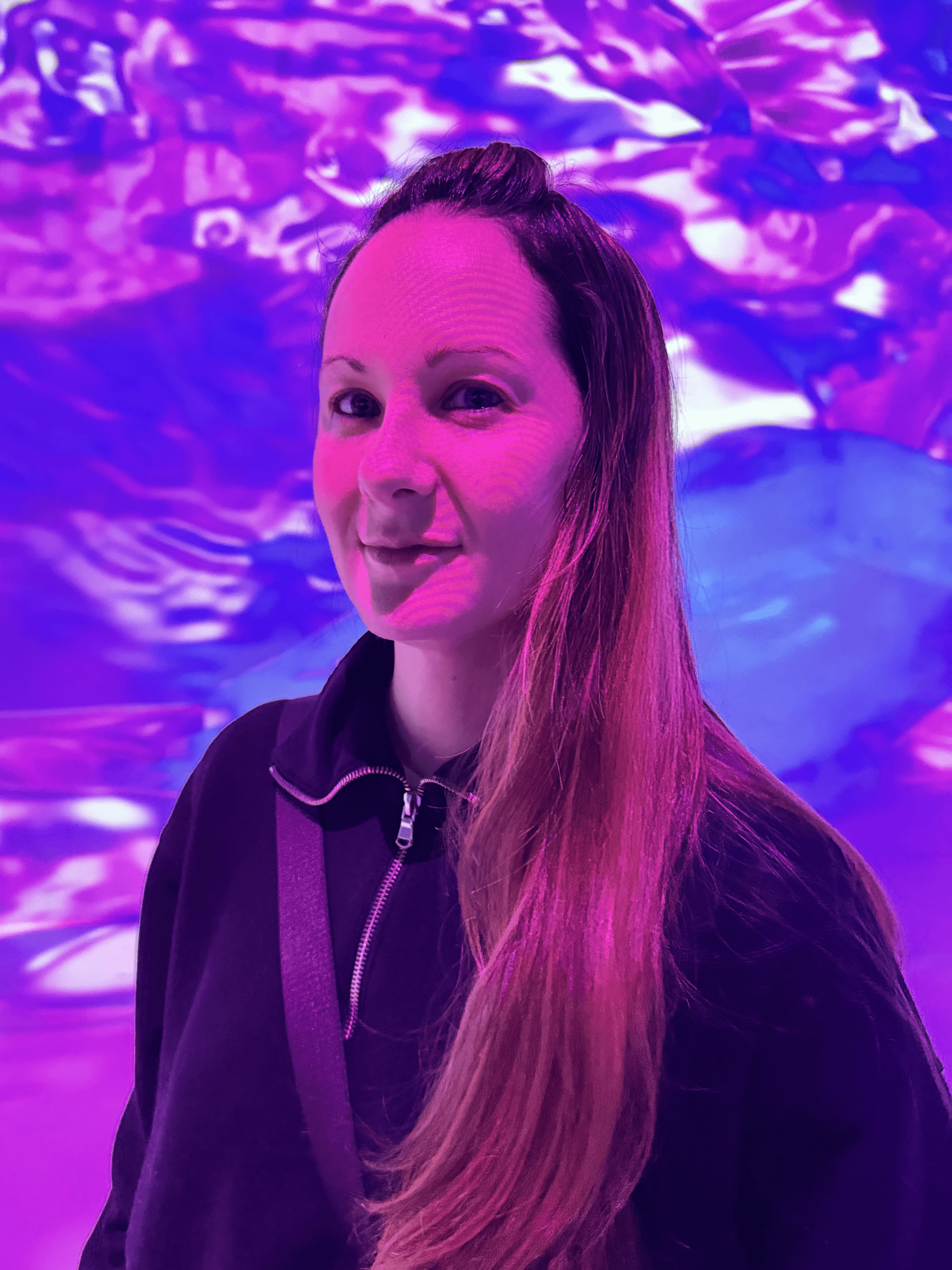 Portrait of a person in a pink sweater against a light background