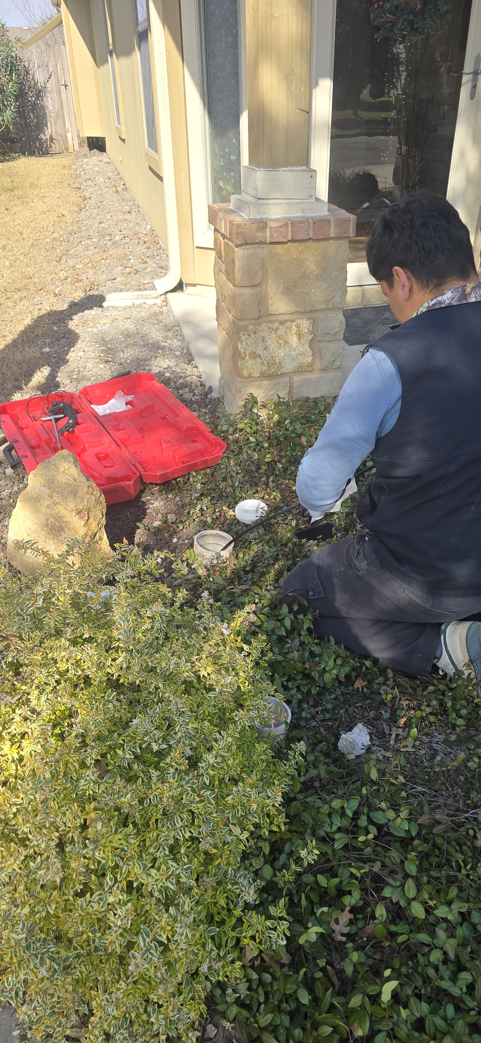 man wearing black pullover hoodie holding tool