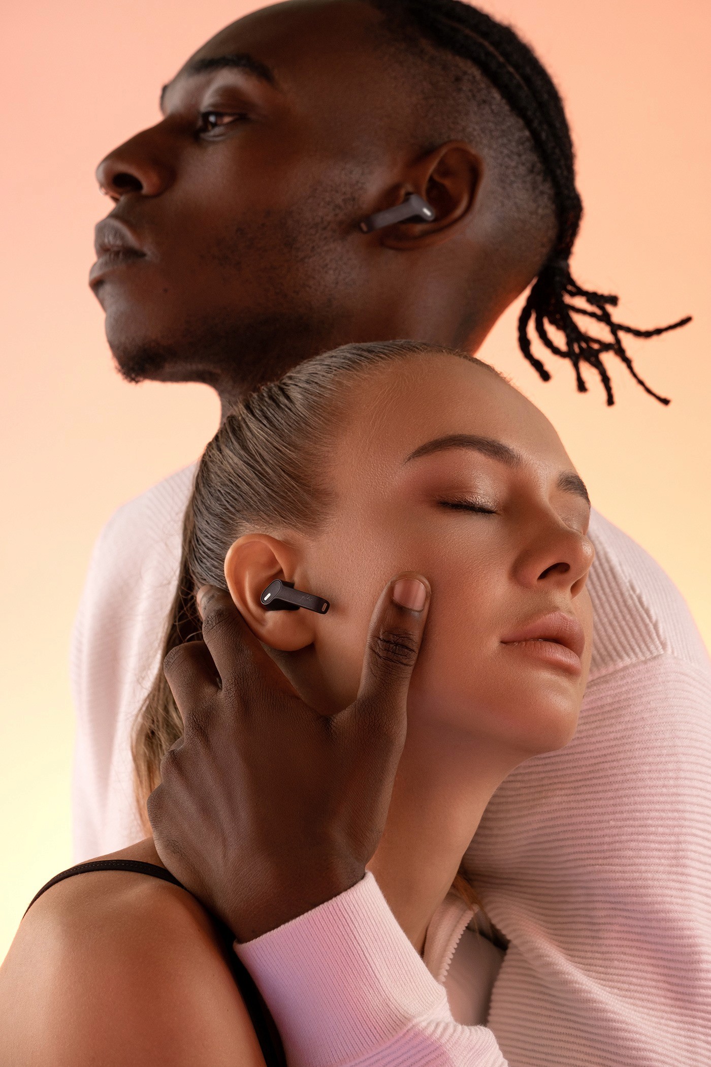 man and woman posing with earbuds
