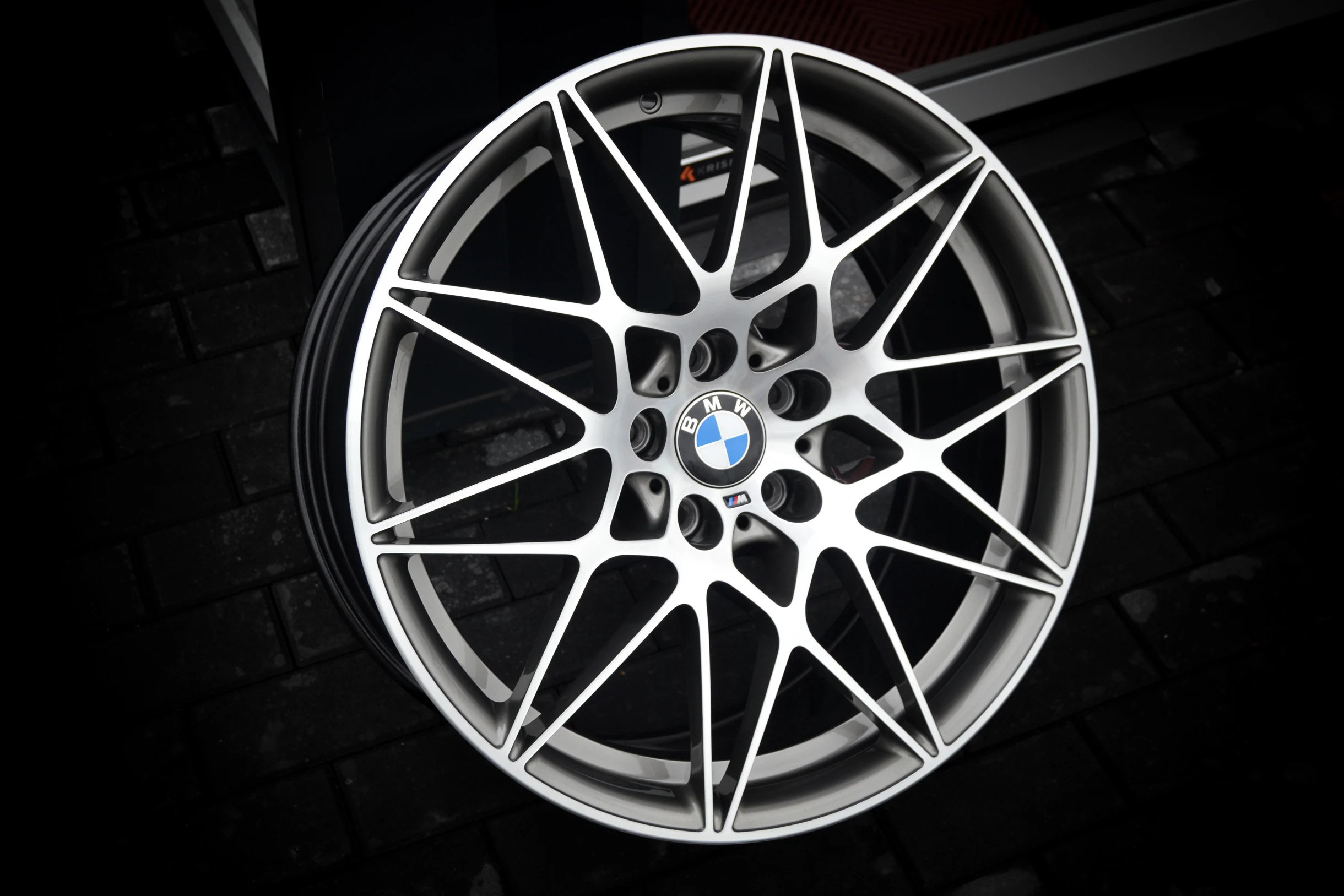 BMW-Kreuzspeichenfelge mit heller, glanzgedrehter Front und dunklen Vertiefungen bei AT Plus.