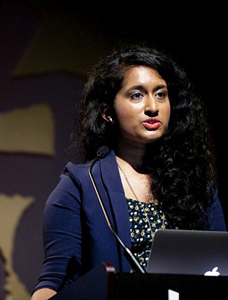 a girl with a blue coat is giving a speech