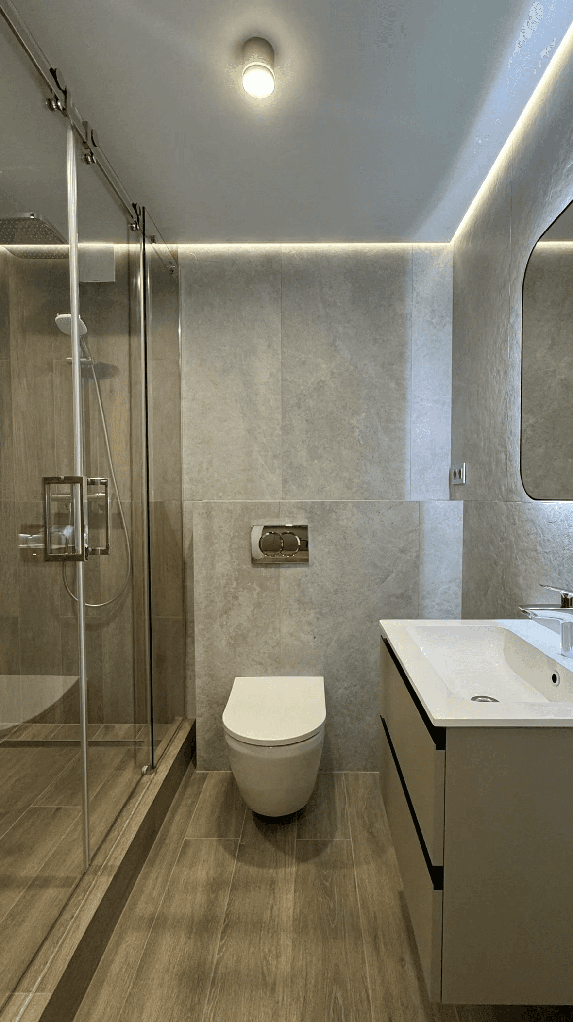 Сучасна ванна кімната з душовою кабіною та лаконічним умивальником