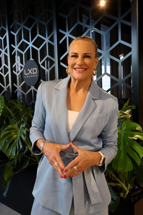 corporate portrait of a woman with her hands together in a blue suit 
