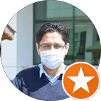 Close-up portrait of a blonde woman in translucent pink glasses and a white shirt on a soft blue background.